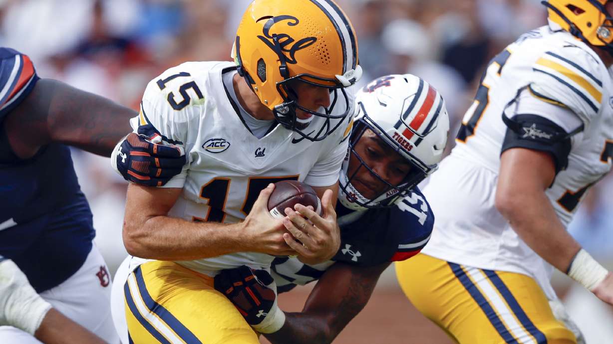 California quarterback Fernando Mendoza, center left, is sacked by Auburn defensive lineman Keldric Faulk, center right, during the first half of an NCAA college football game, Saturday, Sept. 7, 2024, in Auburn, Ala.