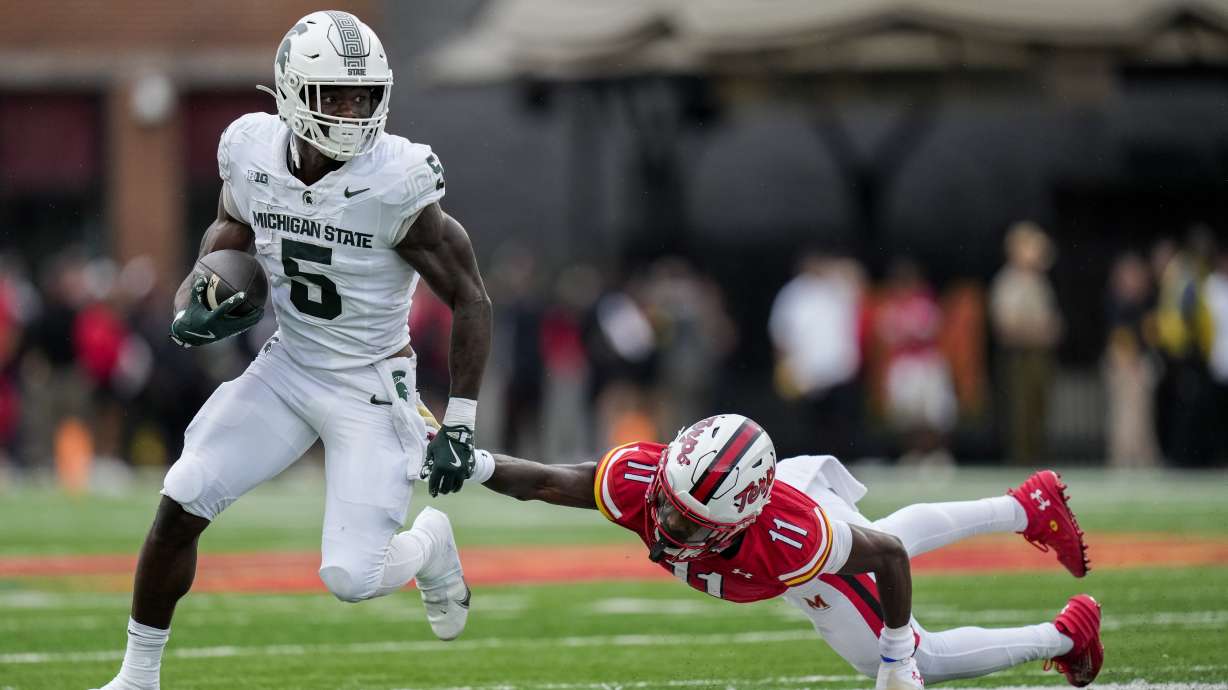 Michigan State running back Nate Carter (5) advances past Maryland defensive back Kevyn Humes (11) during the first half of an NCAA football game, Saturday, Sept. 7, 2024, in College Park, Md.