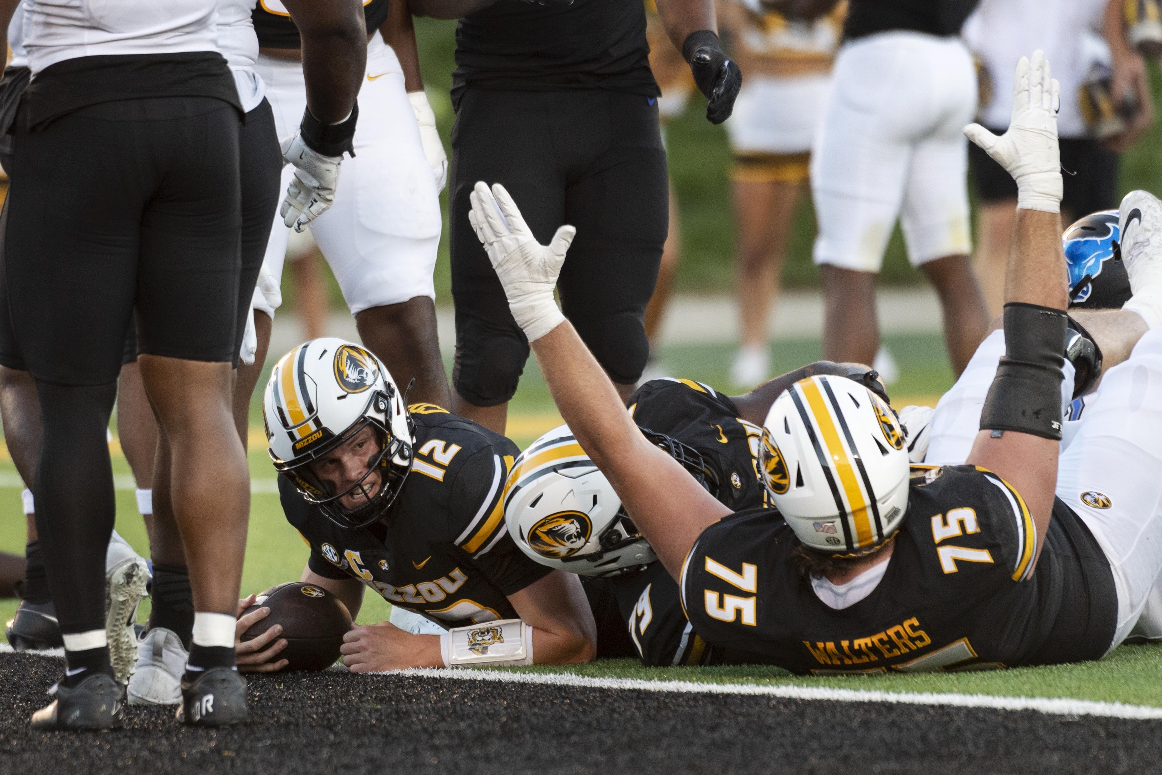 Missouri quarterback Brady Cook (12) looks up after scoring a touchdown as teammate Mitchell Walters (75) celebrates during the first half of an NCAA college football game against Buffalo, Saturday, Sept. 7, 2024, in Columbia, Mo.