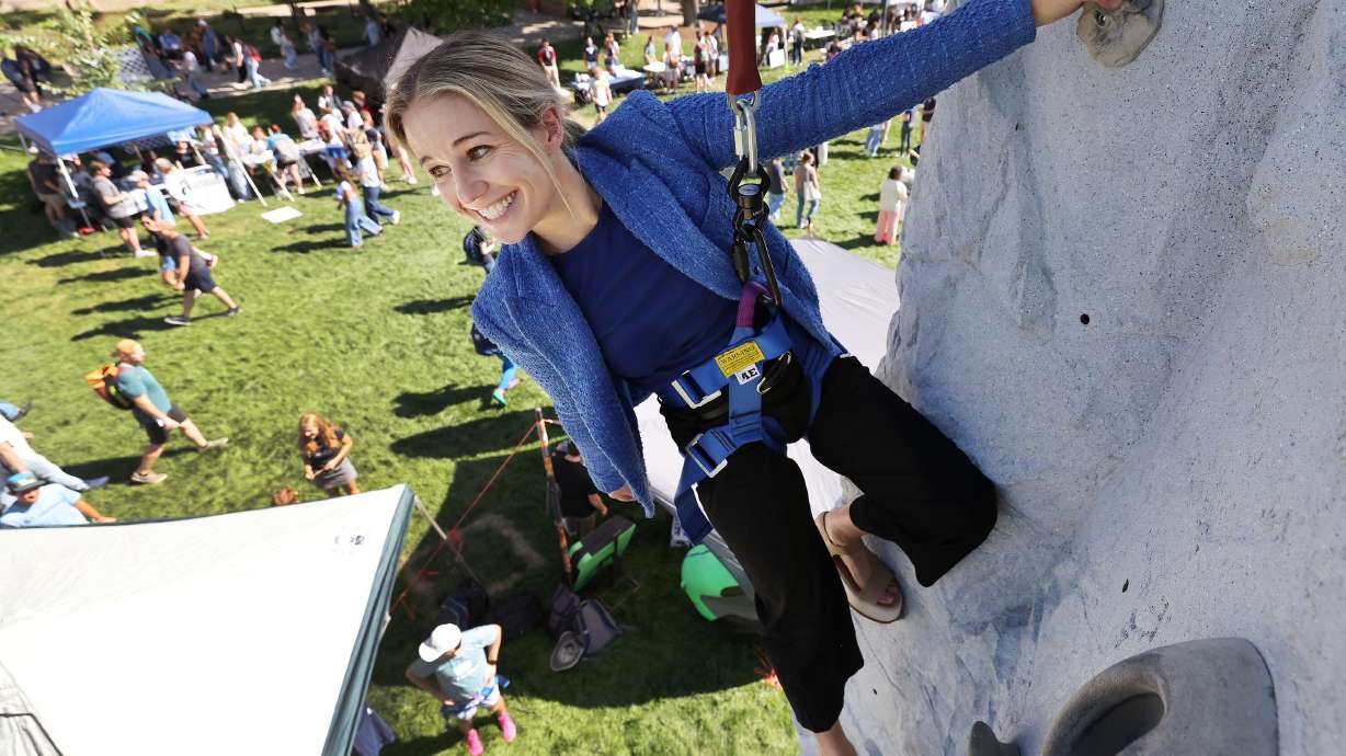 U.S. Senate candidate Caroline Gleich climbs on a climbing wall while meeting with USU college students at the "Day on the Quad — Voter Registration" event in Logan, Aug. 28.