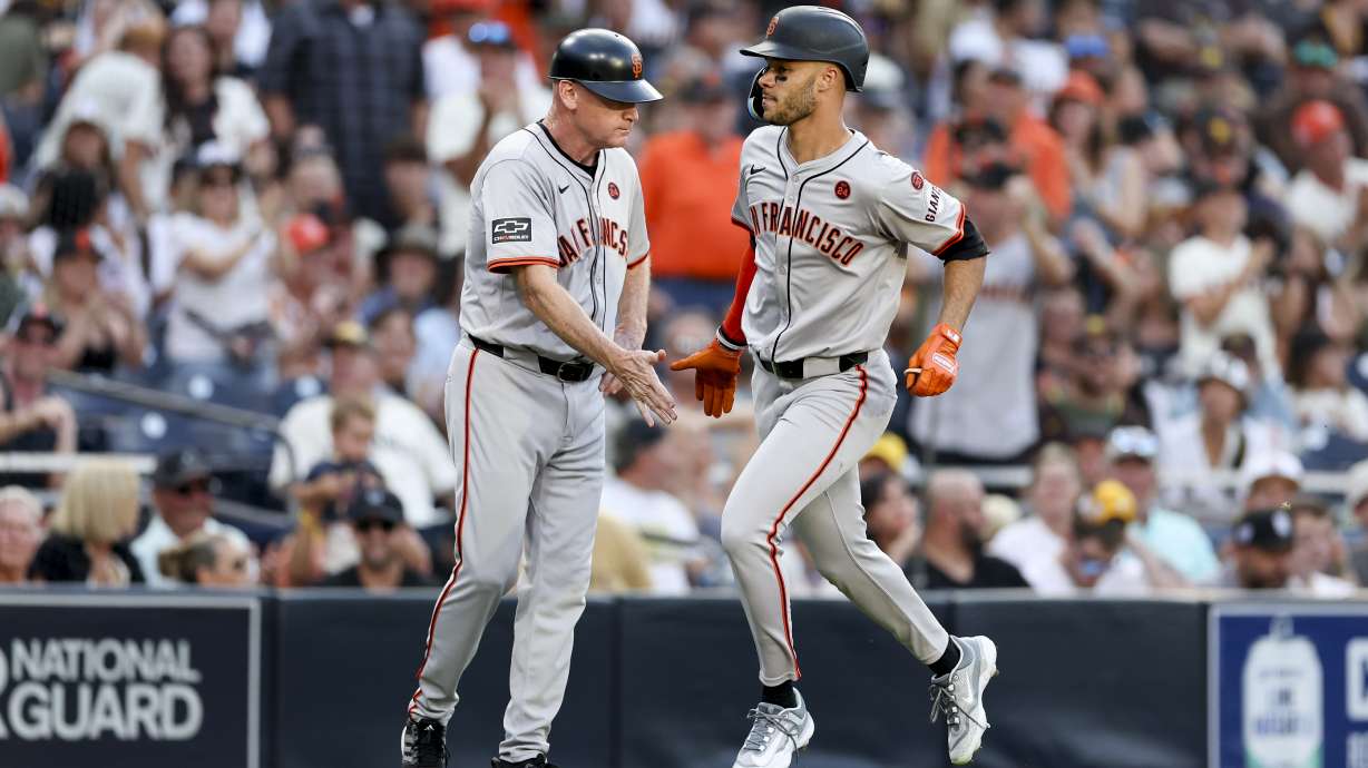San Francisco Giants' Grant McCray, right, celebrates with third base coach Matt Williams, left, after hitting a three-run home run during the second inning of a baseball game against the San Diego Padres, Saturday, Sept. 7, 2024, in San Diego.