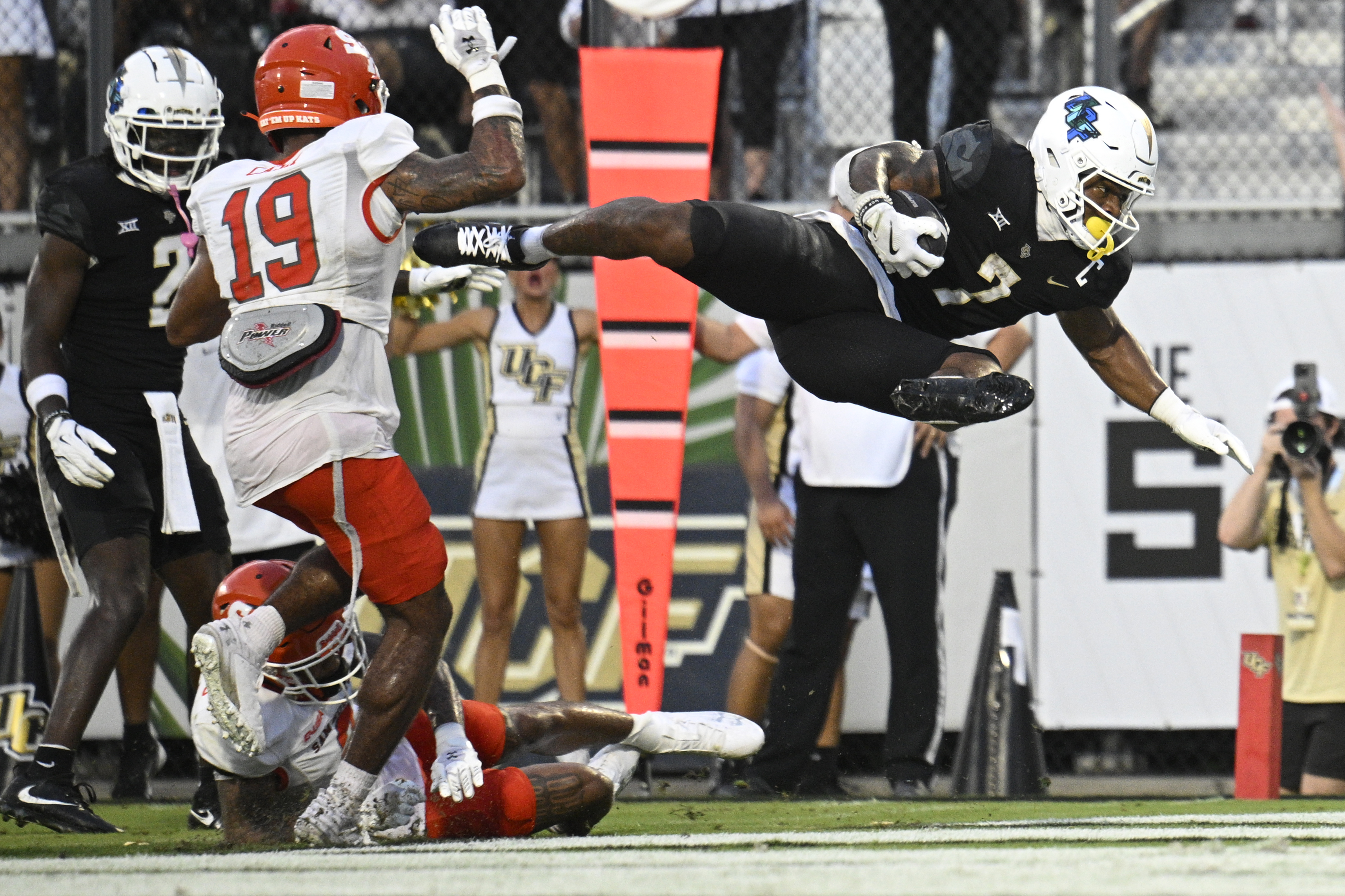 Central Florida running back RJ Harvey (7) leaps over Sam Houston State defensive back Da'Veawn Armstead, bottom, for a rushing touchdown during the first half of an NCAA college football game, Saturday, Sept. 7, 2024 in Orlando, Fla.