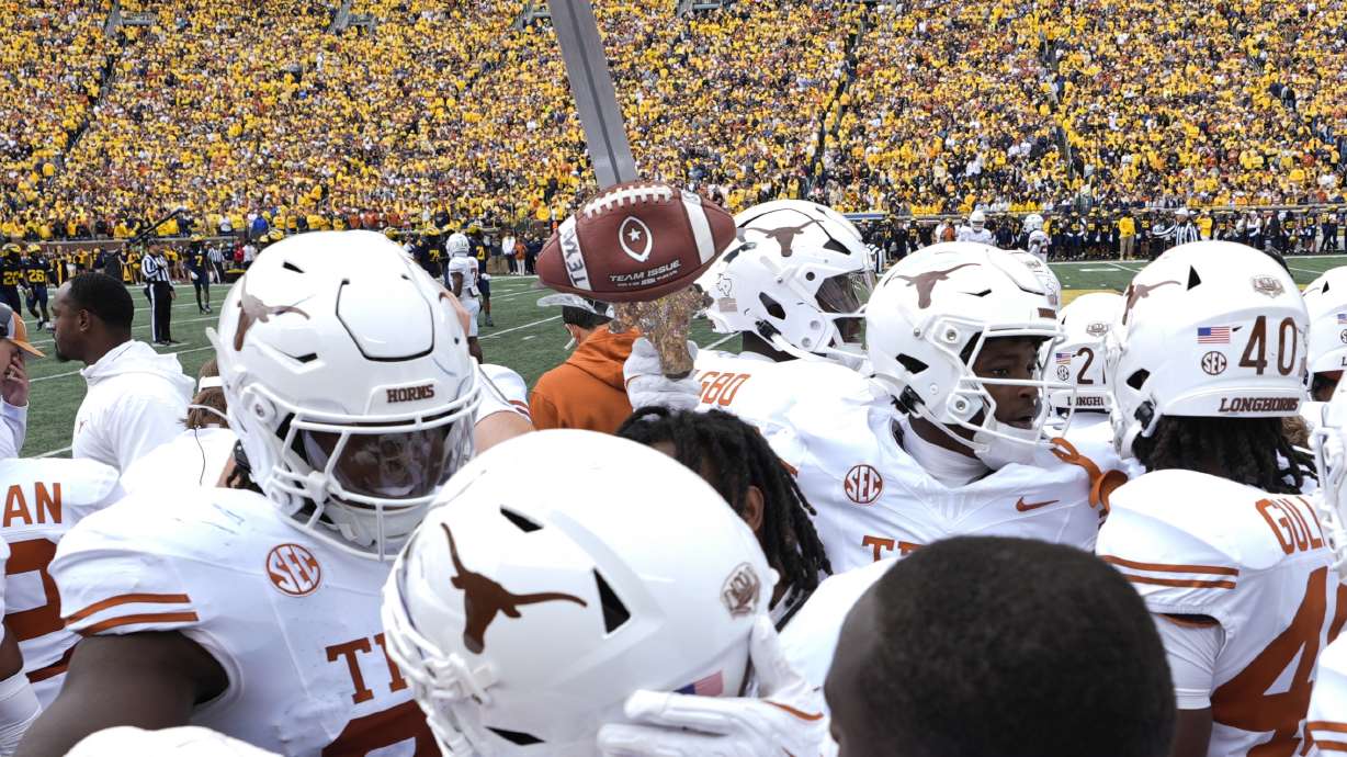 Texas defensive back Andrew Mukuba celebrates his interception with the turnover sword against Michigan in the first half of an NCAA college football game in Ann Arbor, Mich., Saturday, Sept. 7, 2024.
