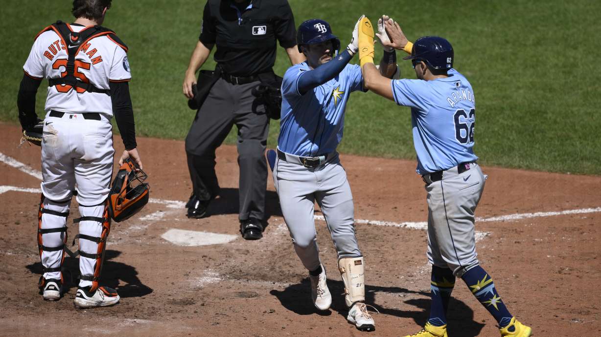 Tampa Bay Rays' Jonny DeLuca, second from right, celebrates his two-run home run with Jonathan Aranda, right, during the sixth inning of a baseball game as Baltimore Orioles catcher Adley Rutschman (35) looks on at left, Sunday, Sept. 8, 2024, in Baltimore.