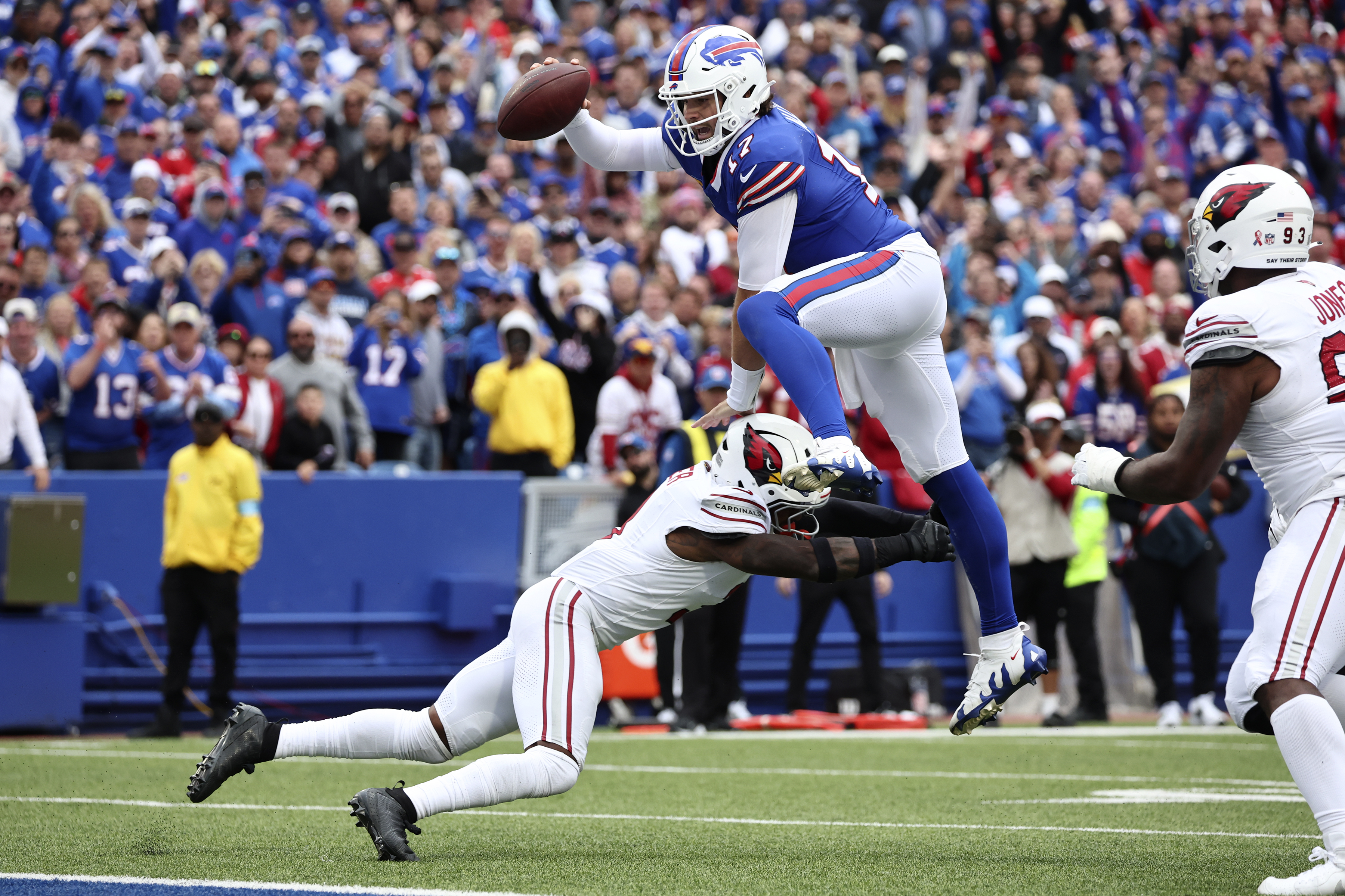 Buffalo Bills quarterback Josh Allen (17) leaps over Arizona Cardinals safety Budda Baker for a touchdown during the second half of an NFL football game Sunday, Sept. 8, 2024, in Orchard Park, N.Y.