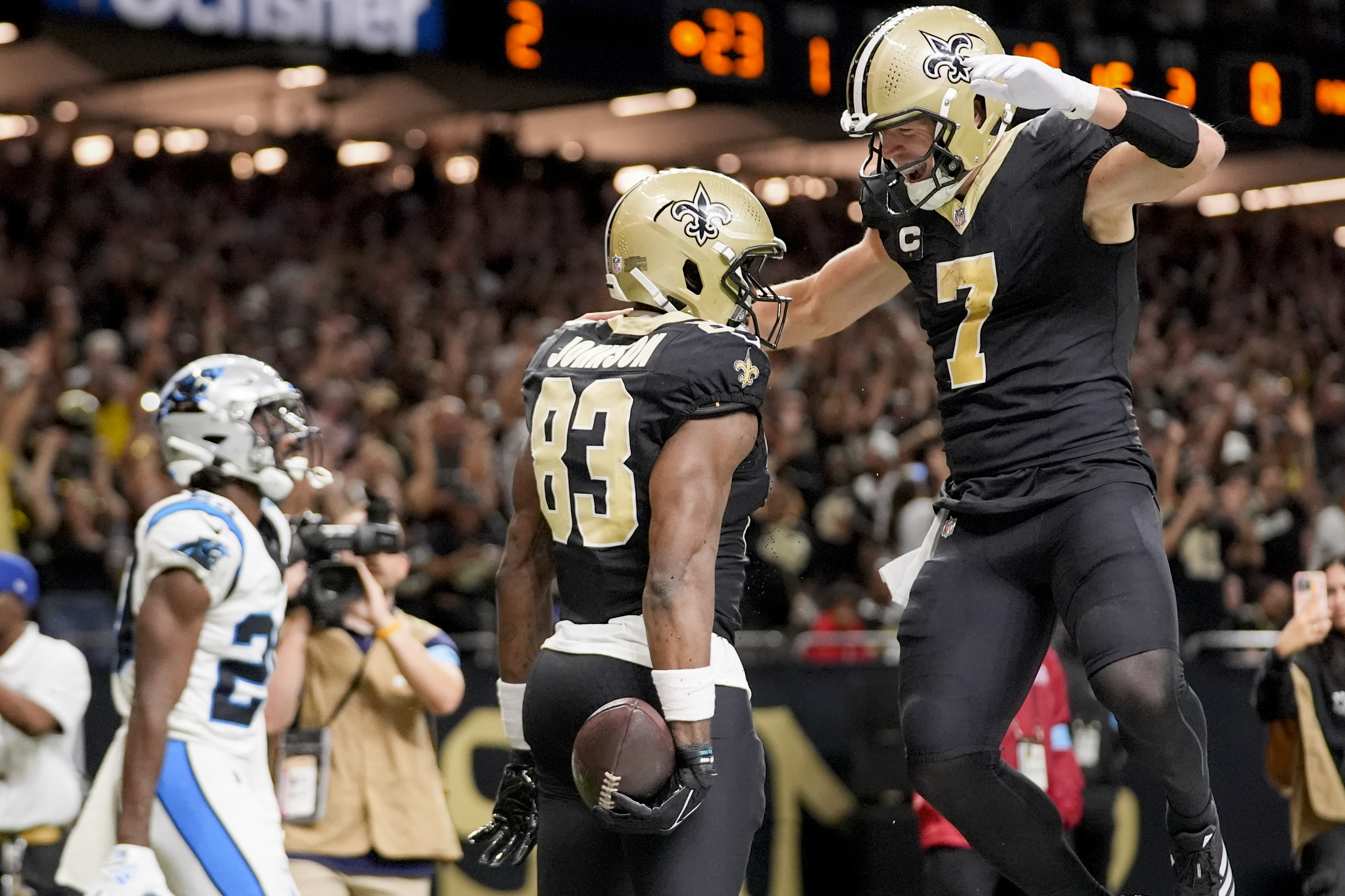New Orleans Saints tight end Juwan Johnson (83) is congratulated by teammate Taysom Hill (7) after scoring a touchdown during the first half of an NFL football game against the Carolina Panthers, Sunday, Sept. 8, 2024, in New Orleans.