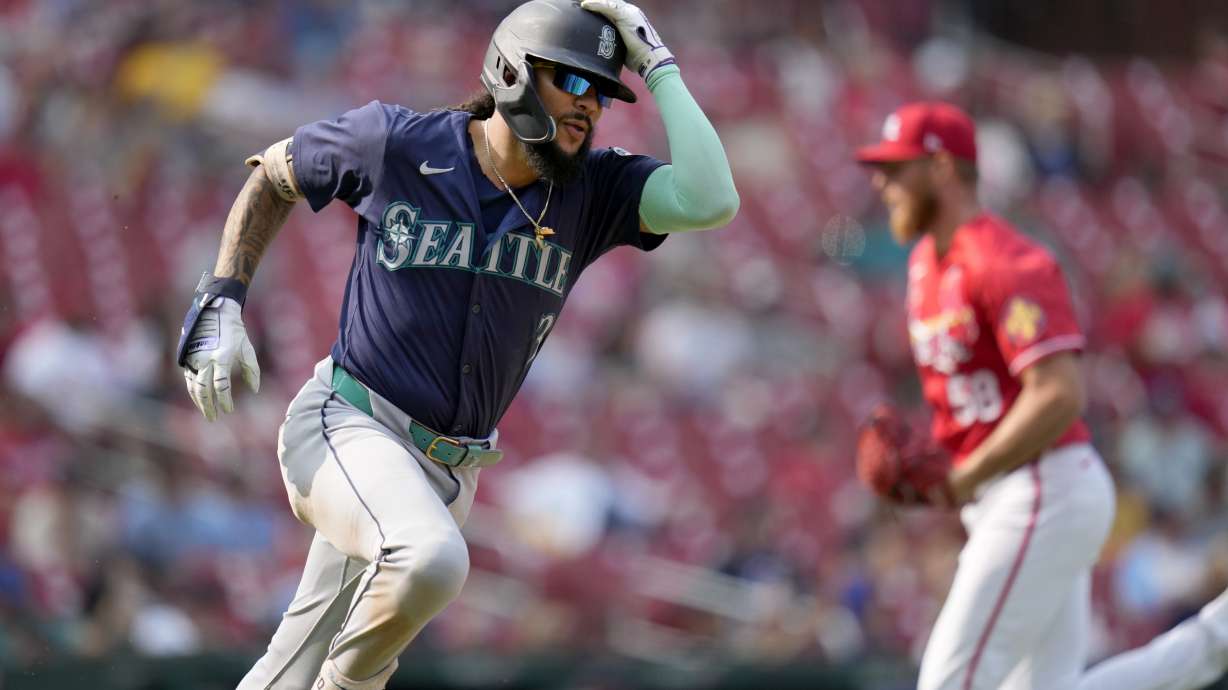 Seattle Mariners' J.P. Crawford, left, rounds first on his way to an RBI double off St. Louis Cardinals pitcher Chris Roycroft, right, during the ninth inning of a baseball game Sunday, Sept. 8, 2024, in St. Louis.