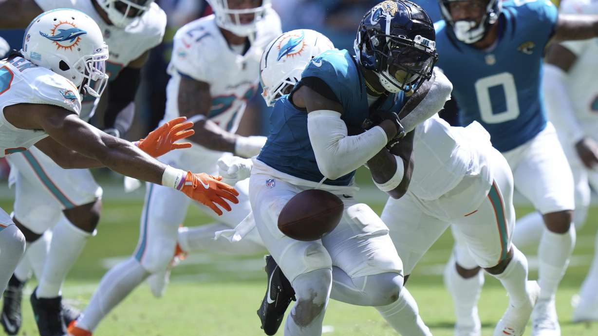 Jacksonville Jaguars running back Travis Etienne Jr. (1) fumbles the ball during the second half of an NFL football game against the Miami Dolphins, Sunday, Sept. 8, 2024, in Miami Gardens, Fla.