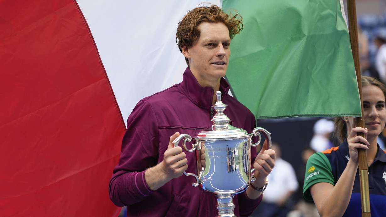 Jannik Sinner, of Italy, holds up the championship trophy after defeating Taylor Fritz, of the United States, in the men's singles final of the U.S. Open tennis championships, Sunday, Sept. 8, 2024, in New York.