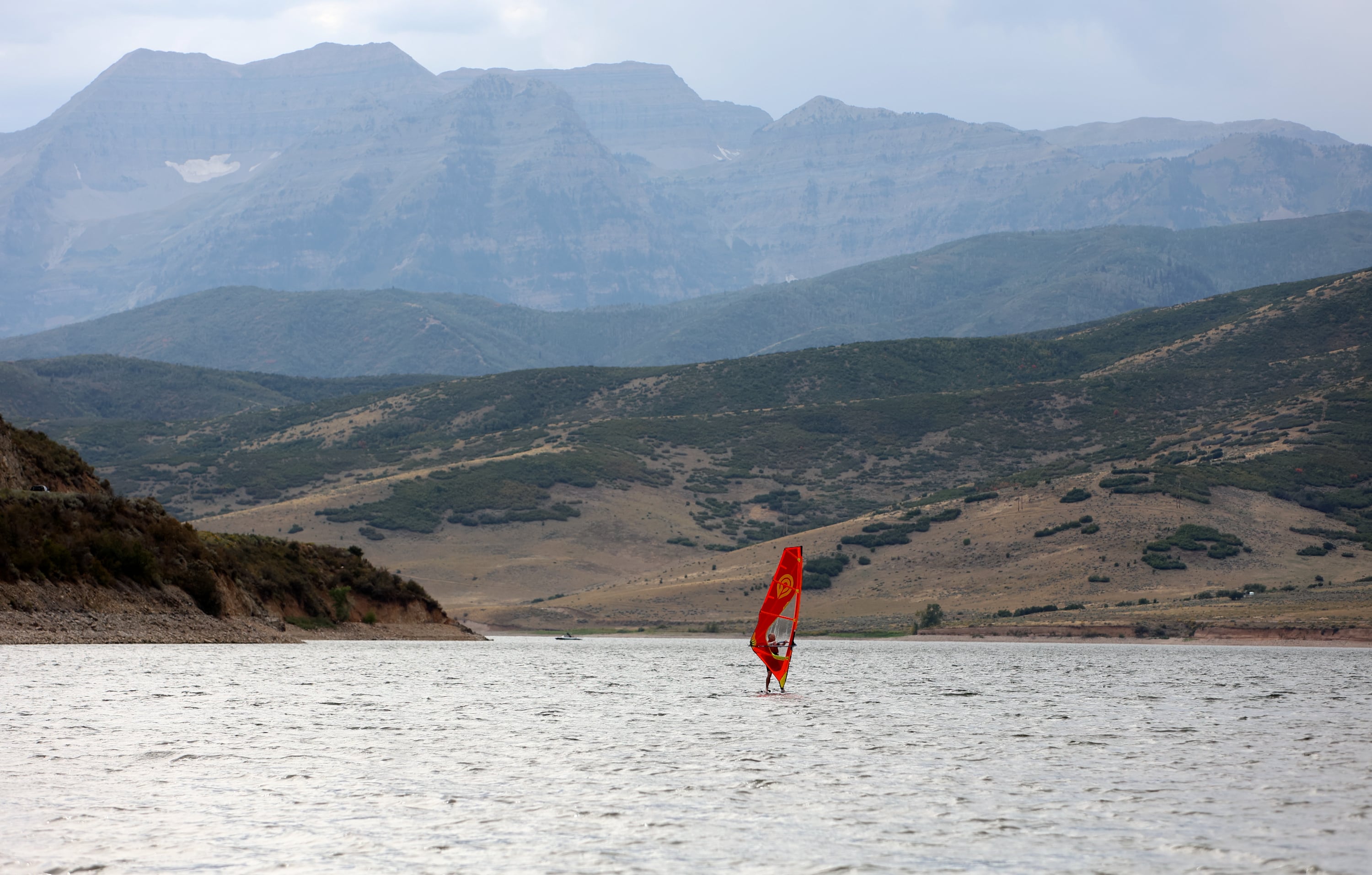 A man windsurfs at Deer Creek Reservoir in Wasatch County on Monday.