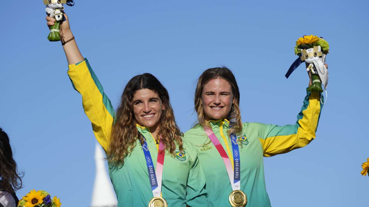 FILE- First placed Brazil's Kahena Kunze, right, and Martine Grael celebrate their gold medal at the end of the women's 49er FX at the 2020 Summer Olympics, Tuesday, Aug. 3, 2021, in Fujisawa, Japan.