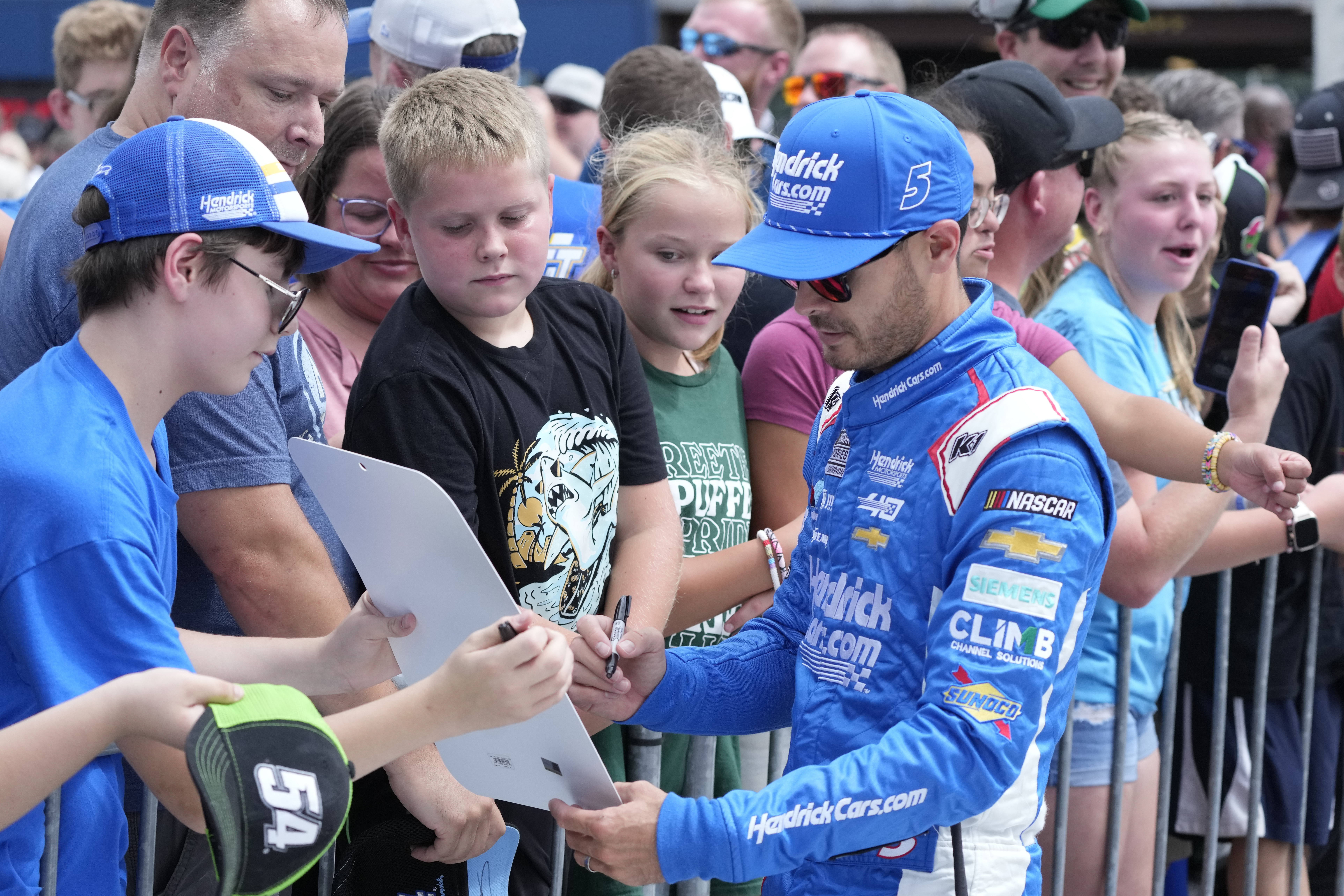 Kyle Larson signs autographs before driver introductions of a NASCAR Cup Series auto race at Michigan International Speedway, Sunday, Aug. 18, 2024, in Brooklyn, Mich.