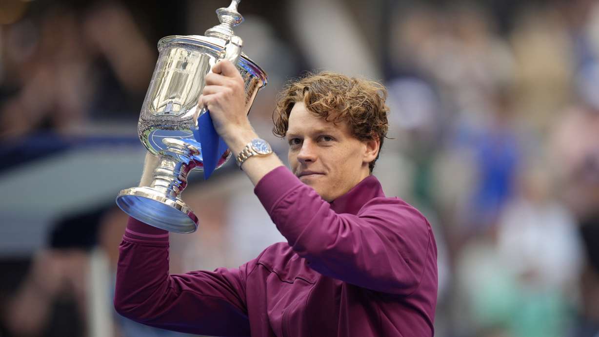 Jannik Sinner, of Italy, holds up the championship trophy after defeating Taylor Fritz, of the United States, in the men's singles final of the U.S. Open tennis championships, Sunday, Sept. 8, 2024, in New York.