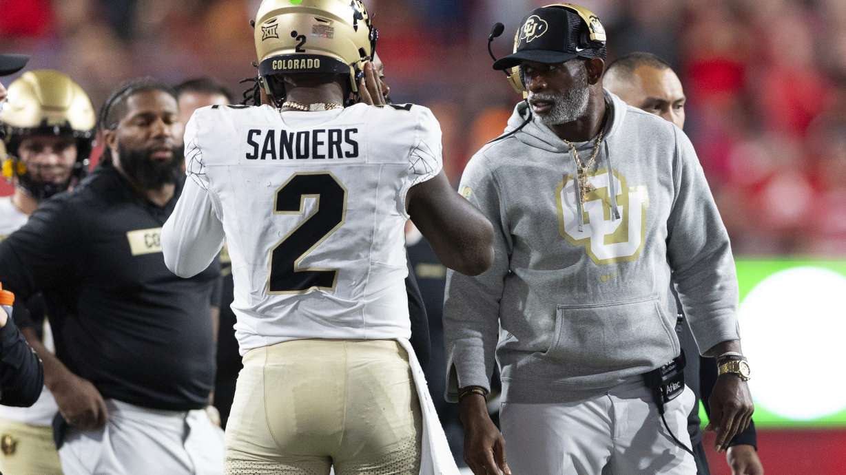 Colorado head coach Deion Sanders, right, talks with quarterback Shedeur Sanders (2) on the sideline between plays against Nebraska during the second half of an NCAA college football game Saturday, Sept. 7, 2024, in Lincoln, Neb.