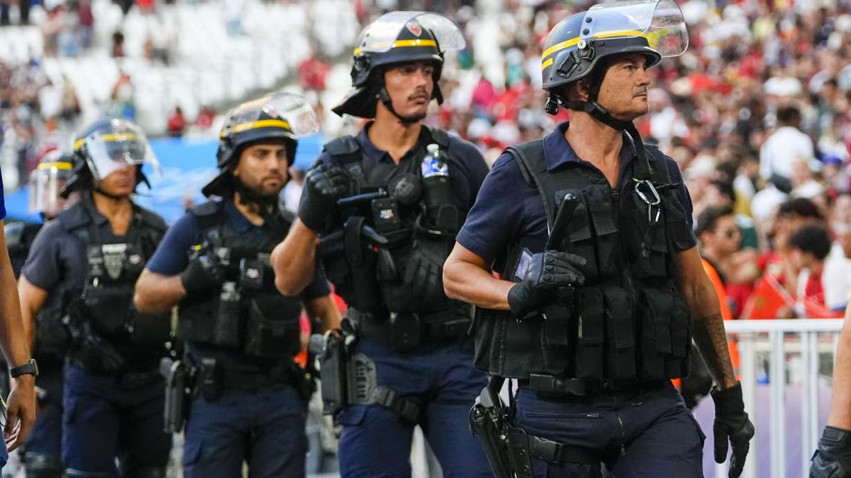 Police are seen near the pitch during a soccer match at the 2024 Summer Olympics, Aug. 5, at Marseille Stadium in Marseille, France. France's counterterrorism prosecutor says authorities foiled three plots to attack the Olympic Games.