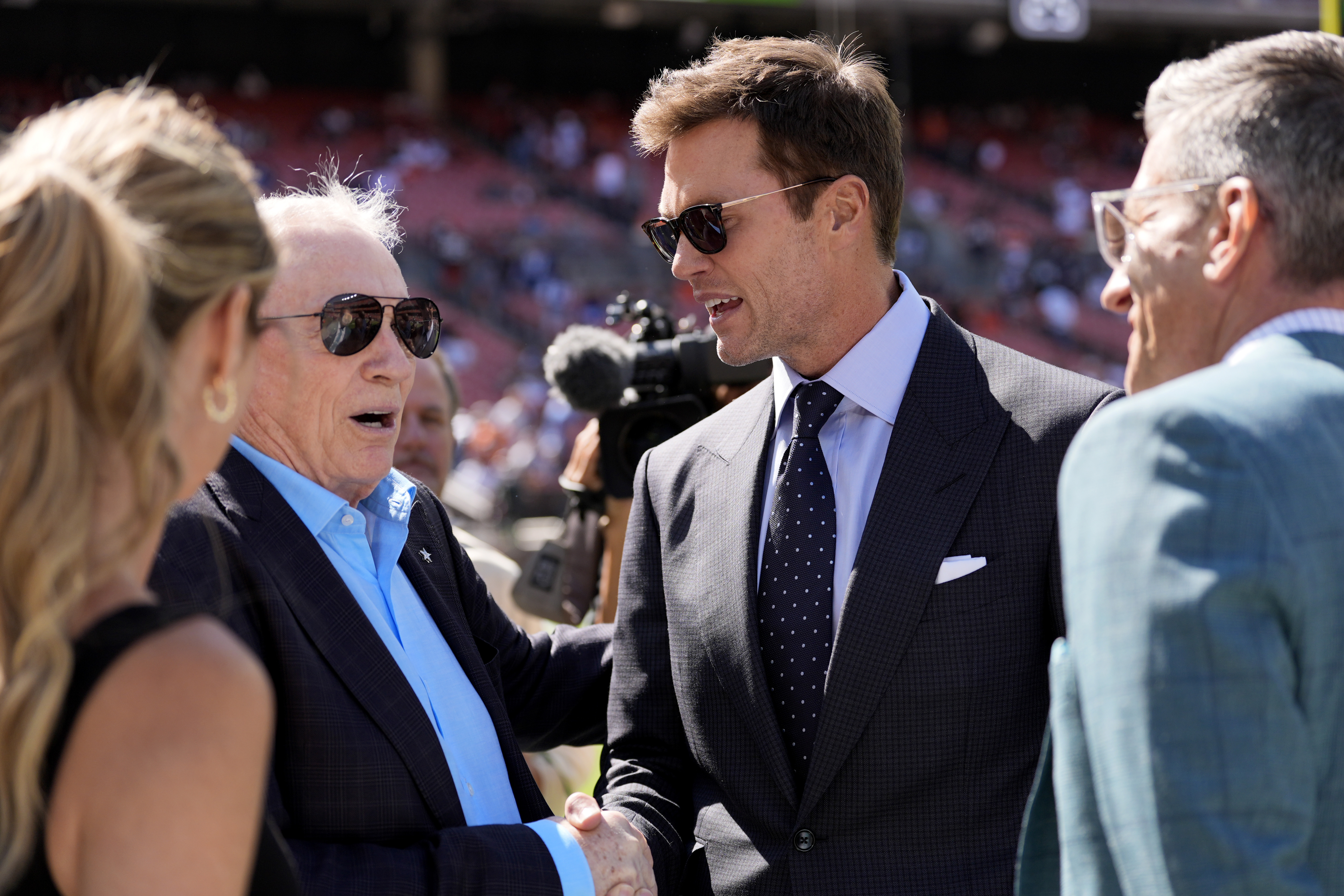 Dallas Cowboys team owner Jerry Jones, left, and analyst Tom Brady, center right, talk with others during team warmups before an NFL football game against the Cleveland Browns in Cleveland, Sunday, Sept. 8, 2024.