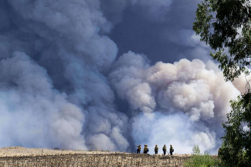Firefighters monitor the Airport Fire from a ridge near Porter Ranch in Trabuco Canyon, Calif., Tuesday.