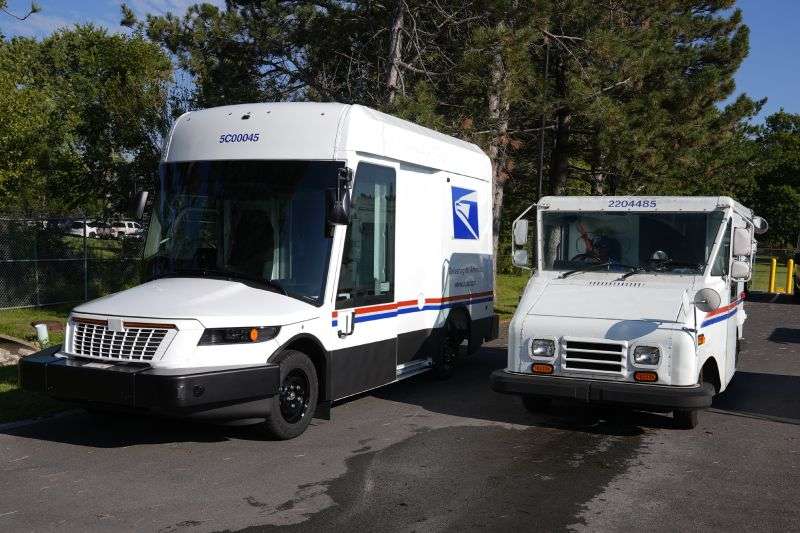 The U.S. Postal Service's next-generation delivery vehicle, left, is displayed as one of the current delivery trucks leaves the Kokomo Sorting and Delivery Center in Kokomo, Ind., Aug. 29.