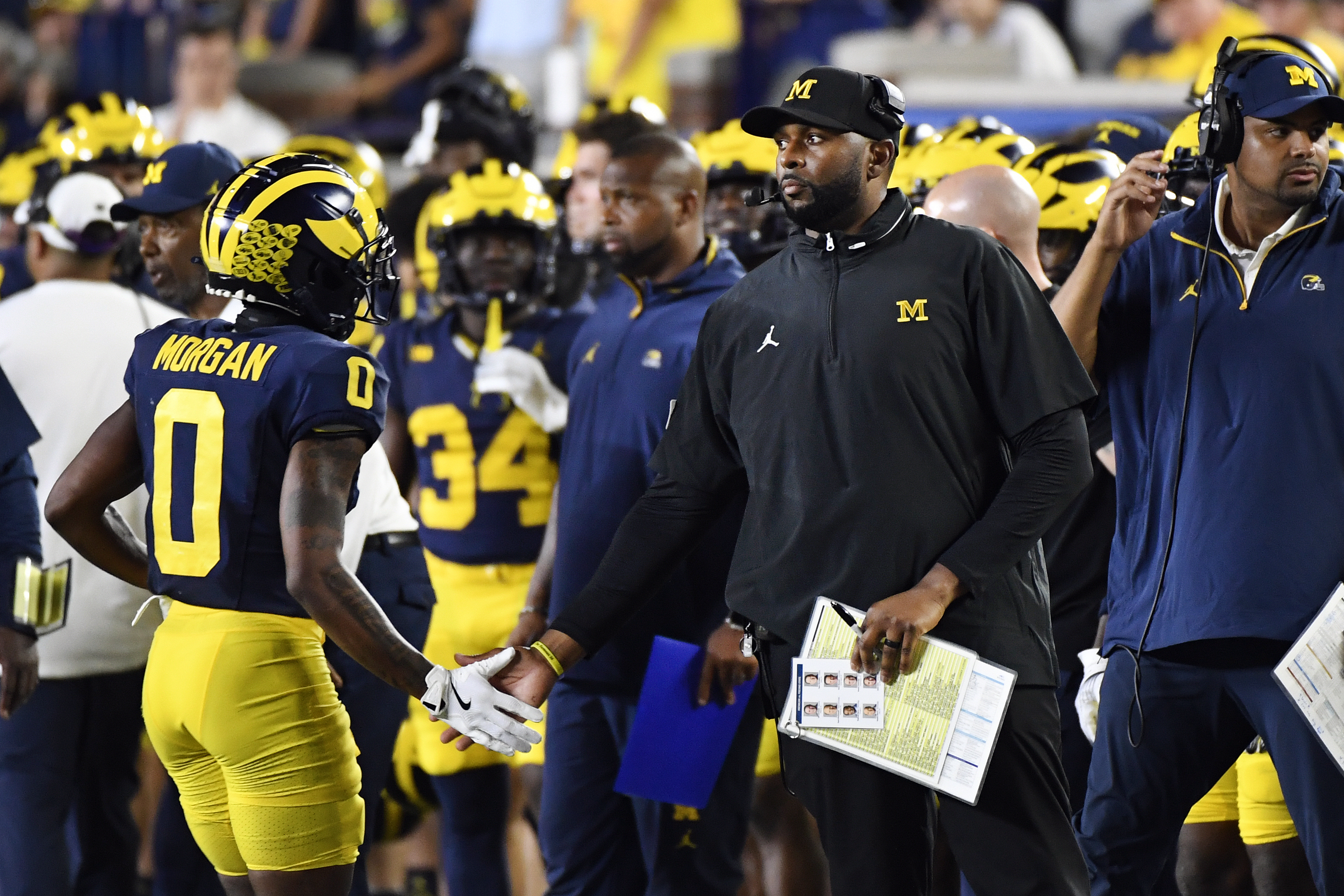 Michigan head coach Sherrone Moore, second from right, congratulates wide receiver Semaj Morgan (0) who comes off the field in the second half of an NCAA college football game against Fresno State, Saturday, Aug. 31, 2024, in Ann Arbor, Mich.