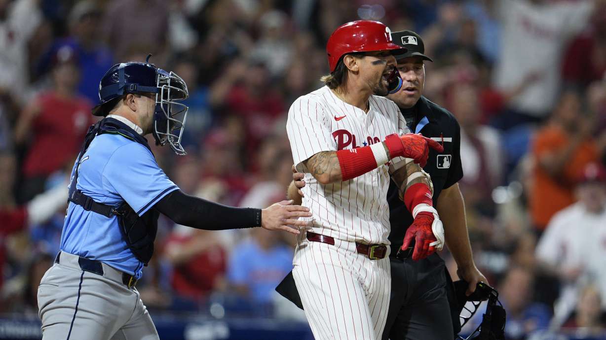 Philadelphia Phillies' Nick Castellanos, center right, reacts after he was hit by a pitch from Tampa Bay Rays' Edwin Uceta as Logan Driscoll, left, and umpire John Libka hold back Castellanos during the eighth inning of a baseball game, Tuesday, Sept. 10, 2024, in Philadelphia.