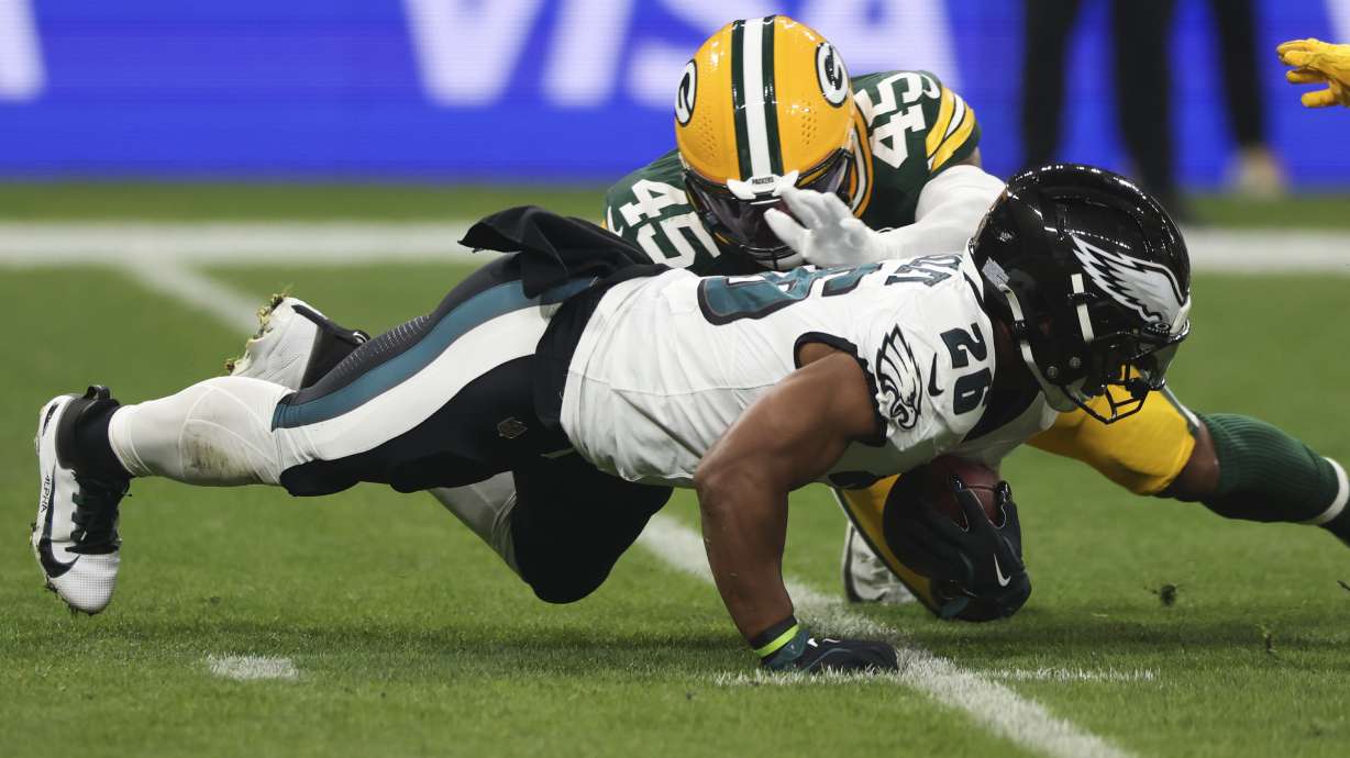 Philadelphia Eagles running back Saquon Barkley (26) is tackled by Green Bay Packers linebacker Eric Wilson (45) during the first half of an NFL football game, Friday, Sept. 6, 2024, at the Neo Quimica Arena in Sao Paulo.