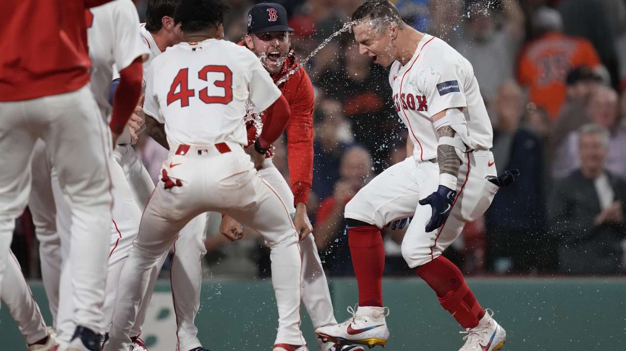 Boston Red Sox's Tyler O'Neill is greeted by teammates at home plate after his game-winning three-run home run in the bottom of the 10th inning of a baseball game against the Baltimore Orioles at Fenway Park, Wednesday, Sept. 11, 2024, in Boston.