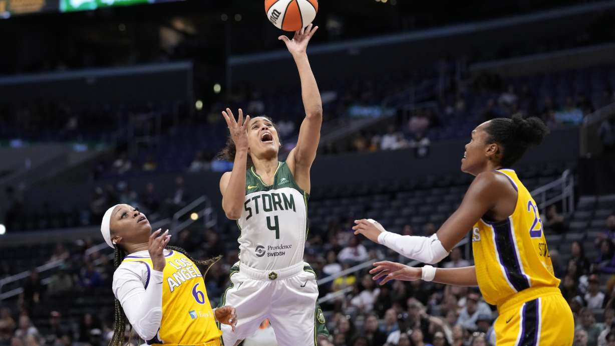 Seattle Storm guard Skylar Diggins-Smith, center, shoots as Los Angeles Sparks' Odyssey Sims, left, and Azura Stevens defend during the first half of a WNBA basketball game, Wednesday, Sept. 11, 2024, in Los Angeles.