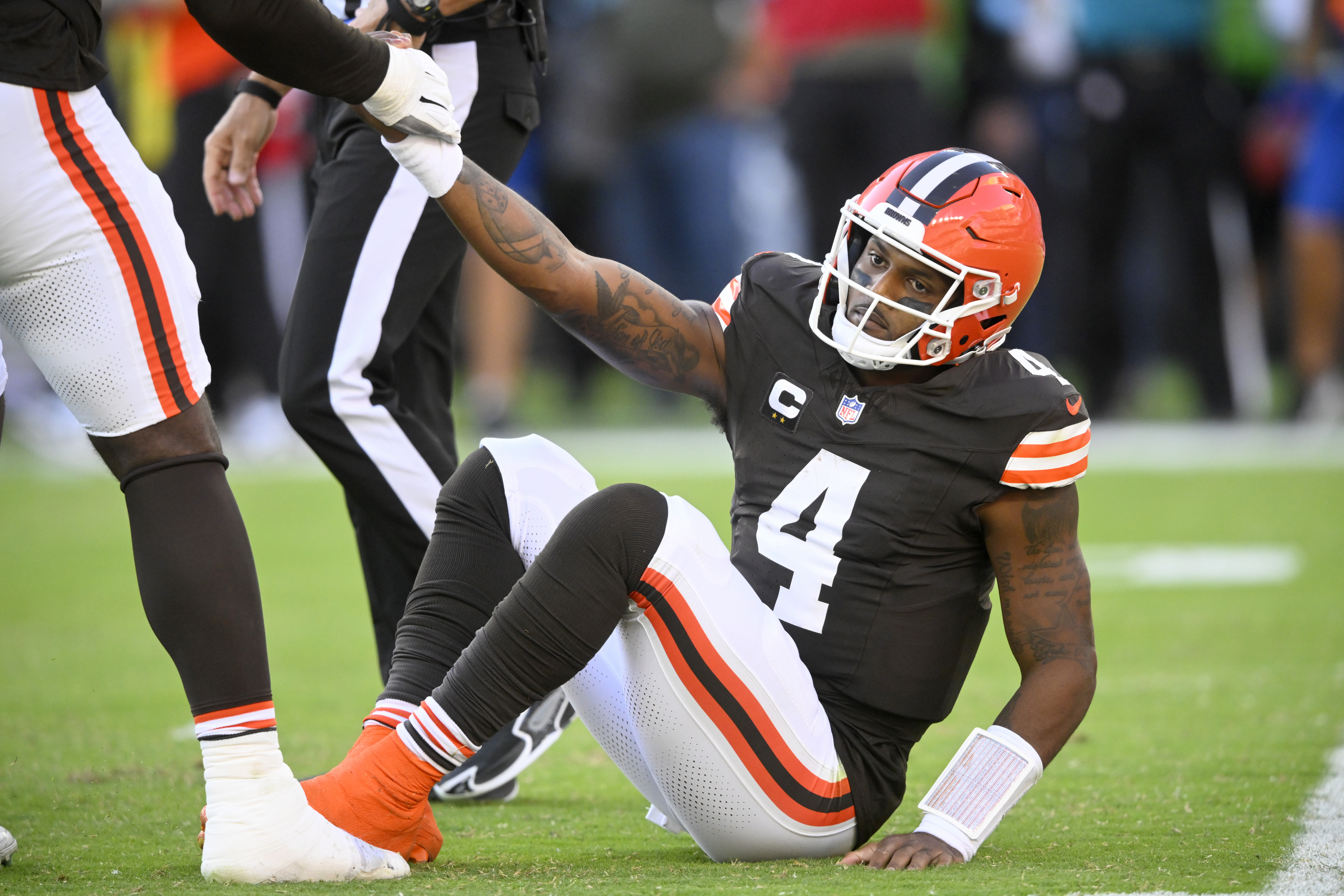 Cleveland Browns quarterback Deshaun Watson (4) is helped up by James Hudson III, left, after Watson threw an incomplete pass in the second half of an NFL football game against the Dallas Cowboys in Cleveland, Sunday, Sept. 8, 2024.