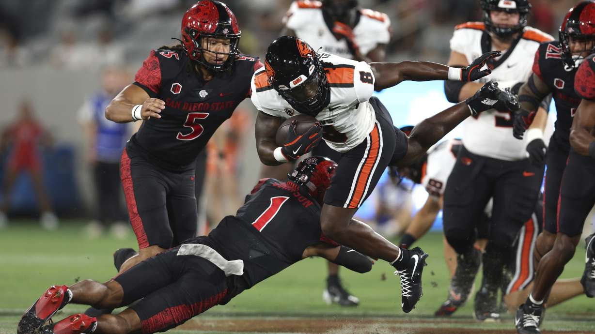 Oregon State running back Jam Griffin (8) is tackled by San Diego State cornerback Chris Johnson (1) by during the first half of an NCAA college football game Saturday, Sept. 7, 2024, in San Diego.