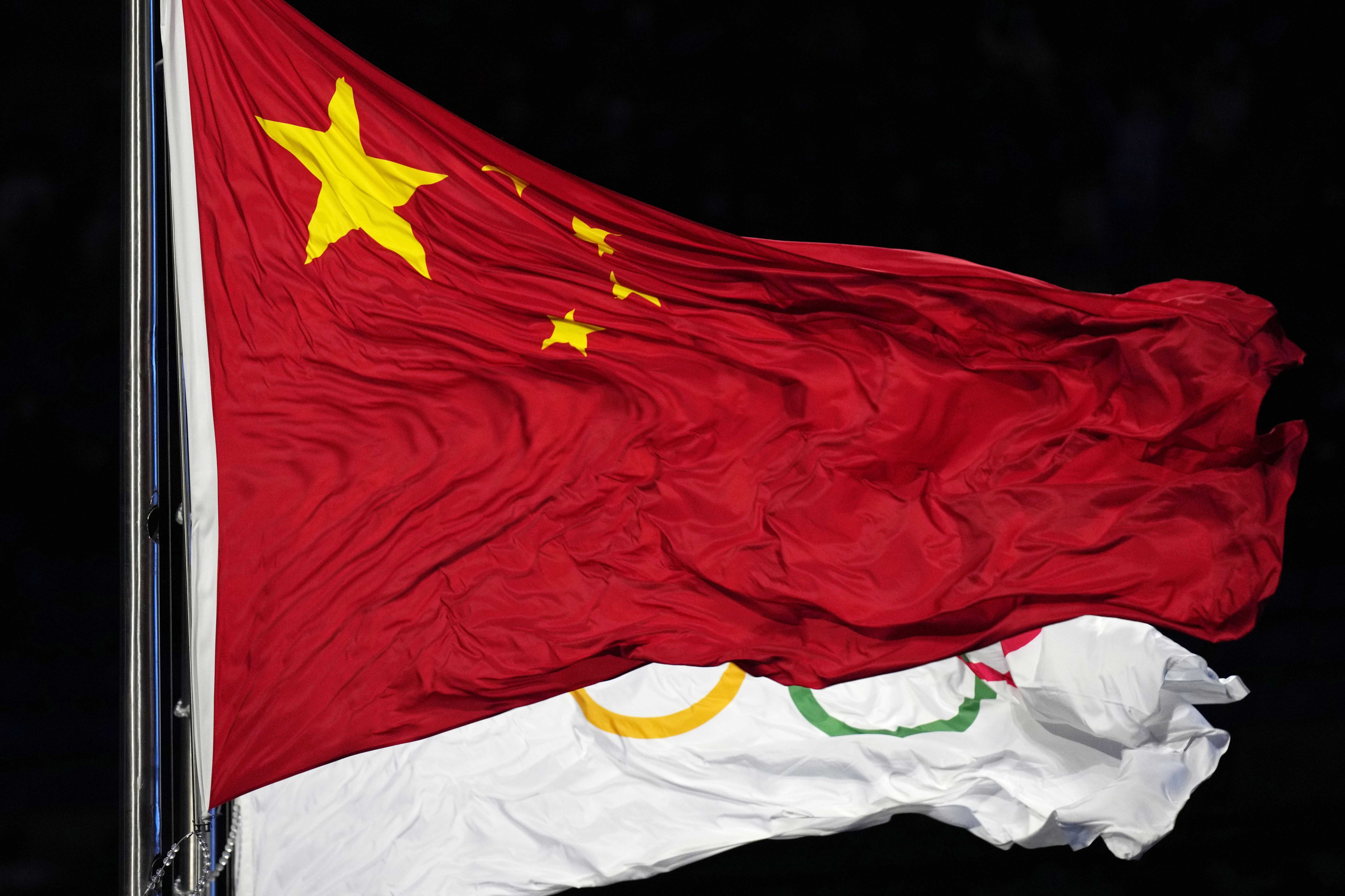 FILE - The Chinese and the Olympic flag wave during the opening ceremony of the 2022 Winter Olympics, Feb. 4, 2022, in Beijing.