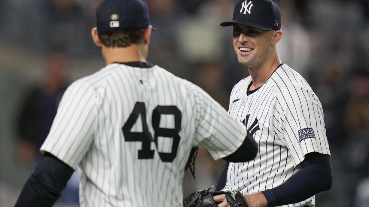 New York Yankees pitcher Clay Holmes, right, is greeted by Anthony Rizzo (48) during the tenth inning of a baseball game against the Boston Red Sox at Yankee Stadium Thursday, Sept. 12, 2024, in New York. The Yankees defeated the Red Sox 2-1.