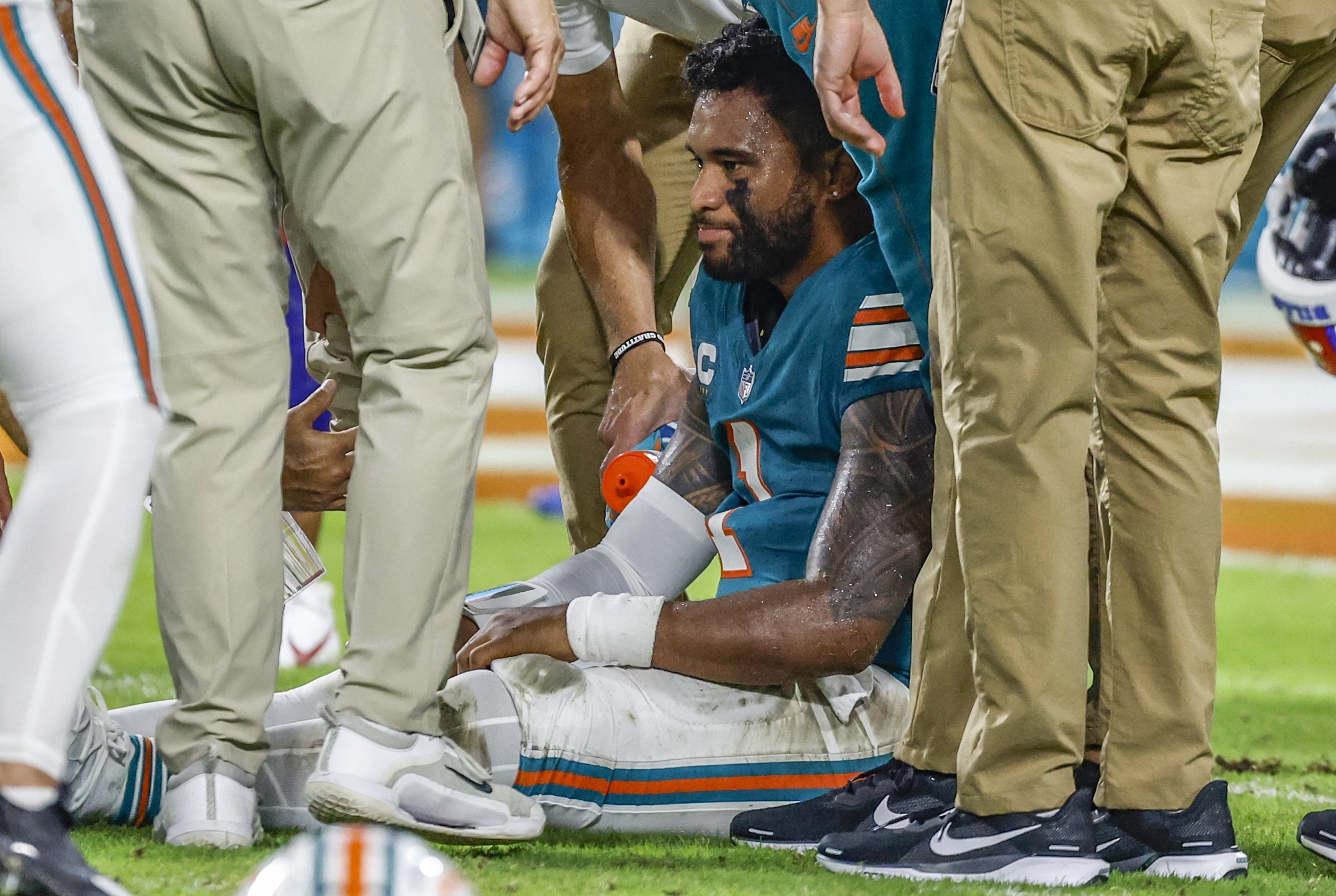 Miami Dolphins quarterback Tua Tagovailoa (1) sits on the field as he is attended to after an injury during the game against the Buffalo Bills in the second half of an NFL football game on Thursday, Sept. 12, 2024.