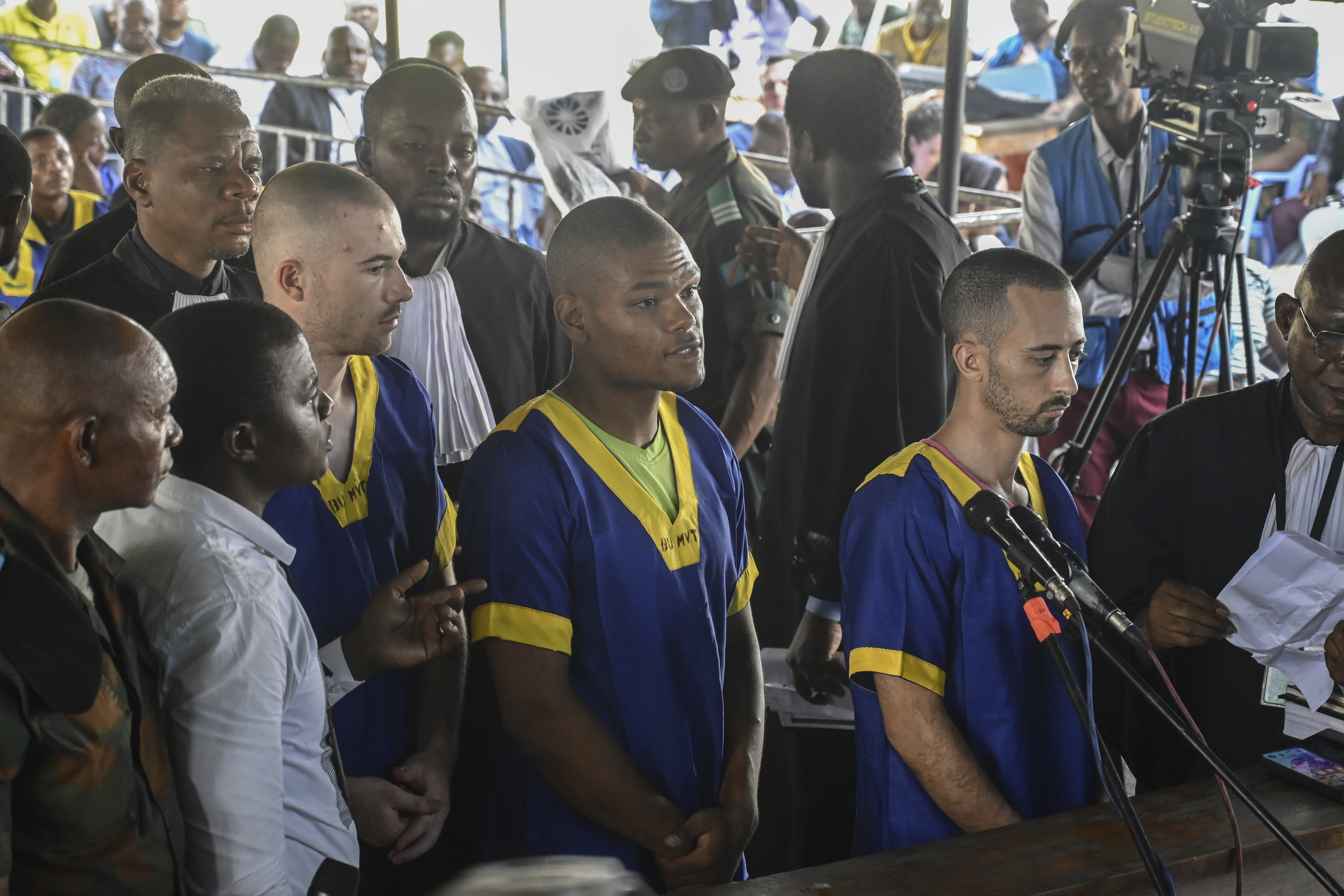 From left, Tyler Thompson Jr, Marcel Malanga and Benjamin Reuben Zalman-Polun, all American citizens, face the court in Kinshasa with 52 other defendants on June 7 accused of a role in an attempted coup in Congo.