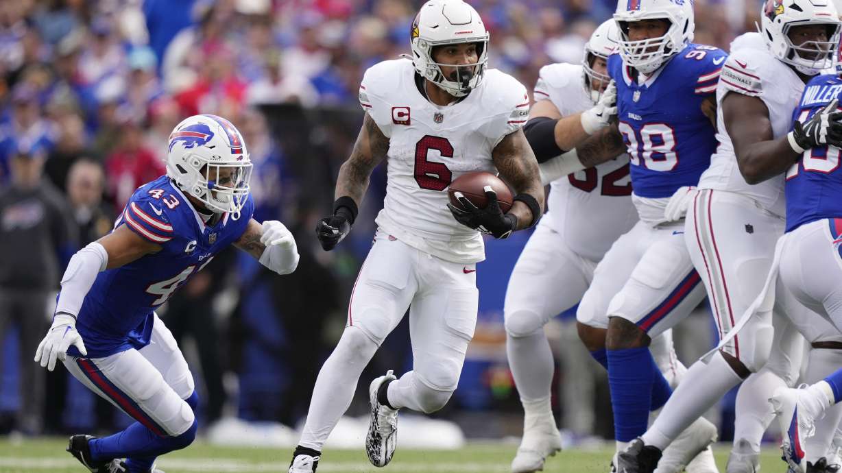 Arizona Cardinals running back James Conner (6) runs past Buffalo Bills linebacker Terrel Bernard (43) and Bills defensive tackle Austin Johnson, right, during the second half of an NFL football game Sunday, Sept. 8, 2024, in Orchard Park, N.Y.
