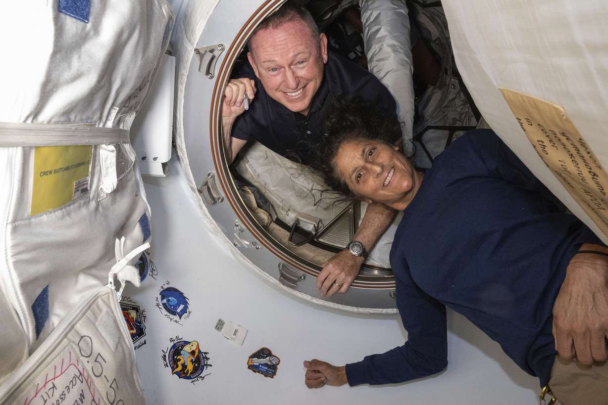 In this photo provided by NASA, Boeing Crew Flight Test astronauts Butch Wilmore, left, and Suni Williams pose for a portrait inside the vestibule between the forward port on the International Space Station's Harmony module and Boeing's Starliner spacecraft on June 13.