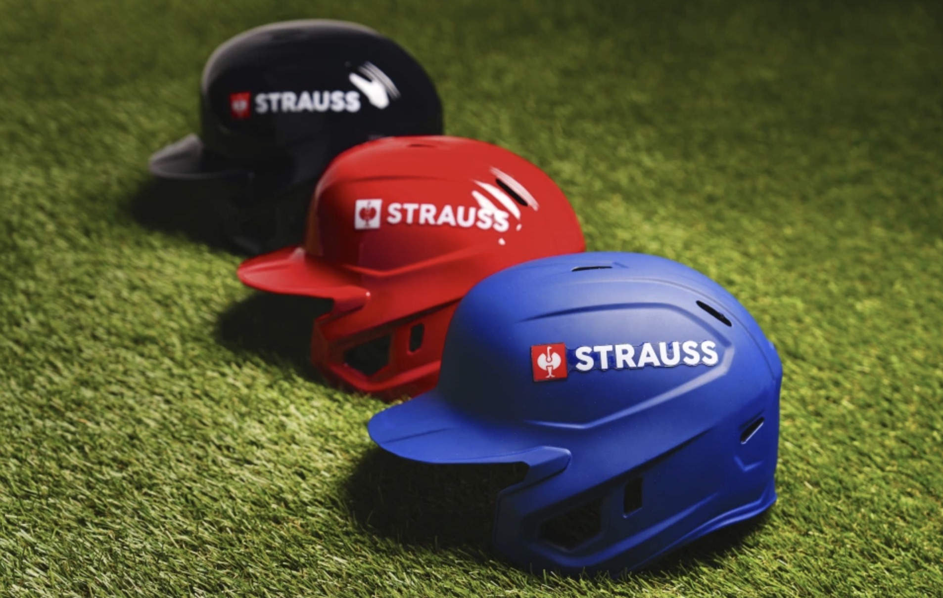 This Major League Baseball photo shows batting helmets with the Strauss logo, taken Thursday at Major League Baseball headquarters in New York. The Salt Lake Bees will wear the logo on their helmets starting next year.