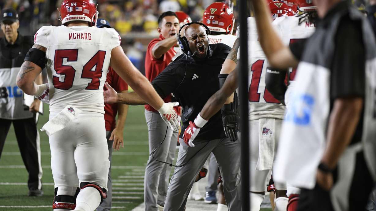 Fresno State interim head coach Tim Skipper, middle, congratulates his players after a touchdown by Raylen Sharpe against Michigan in the second half of an NCAA college football game, Saturday, Aug. 31, 2024, in Ann Arbor, Mich.