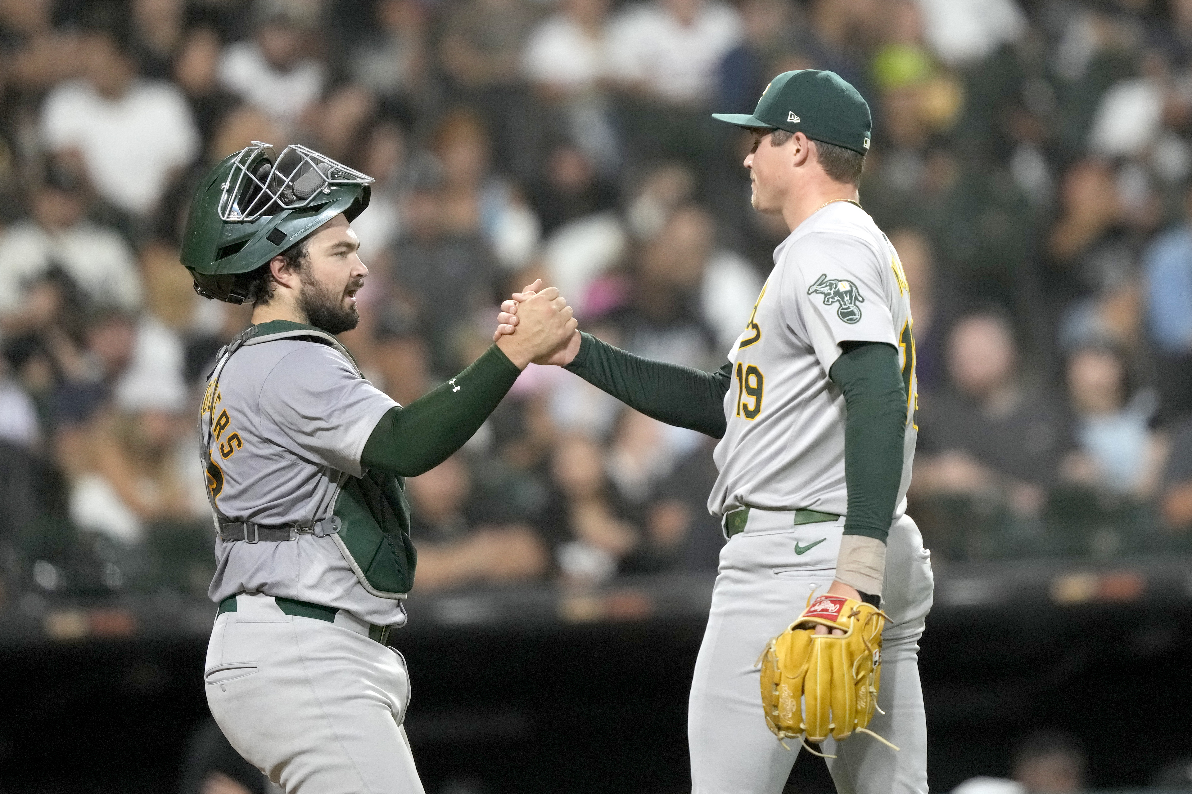 Oakland Athletics relief pitcher Mason Miller, right, and catcher Shea Langeliers celebrate after the team's 2-0 shutout of the Chicago White Sox in a baseball game Friday, Sept. 13, 2024, in Chicago.