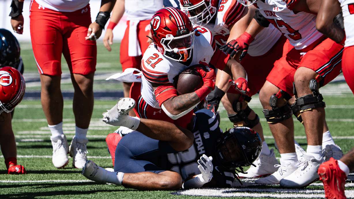 Utah running back Mike Mitchell fights for yards on a run against Utah State at Maverik Stadium in Logan on Sept. 14, 2024.
