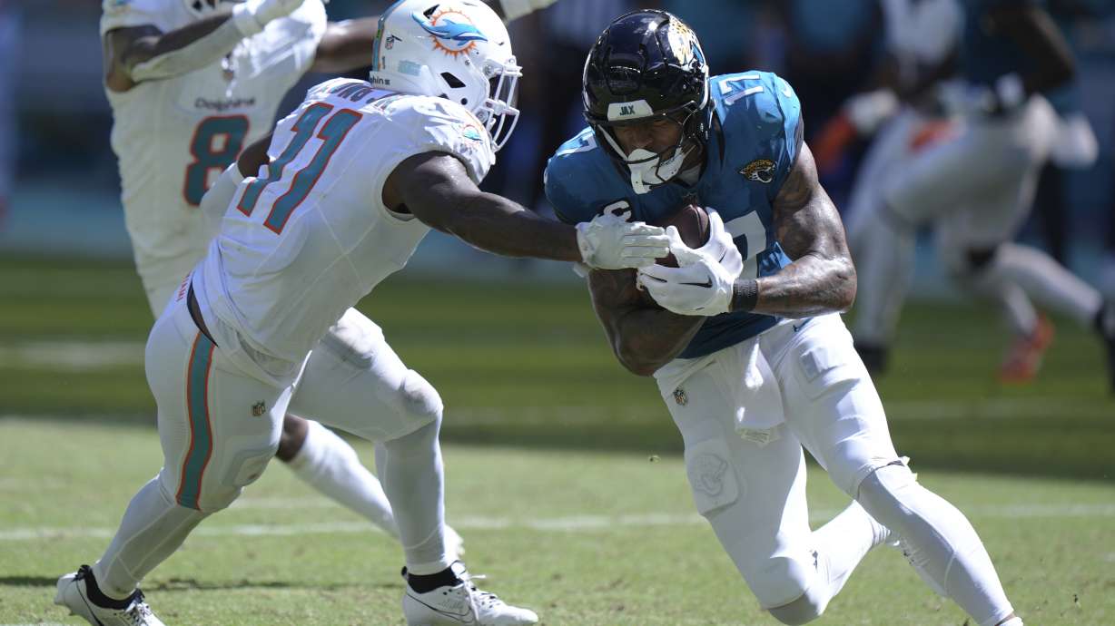 Jacksonville Jaguars tight end Evan Engram (17) runs with the football as Miami Dolphins linebacker David Long Jr. (11) attempts to stop him during the second half of an NFL football game, Sunday, Sept. 8, 2024, in Miami Gardens, Fla.