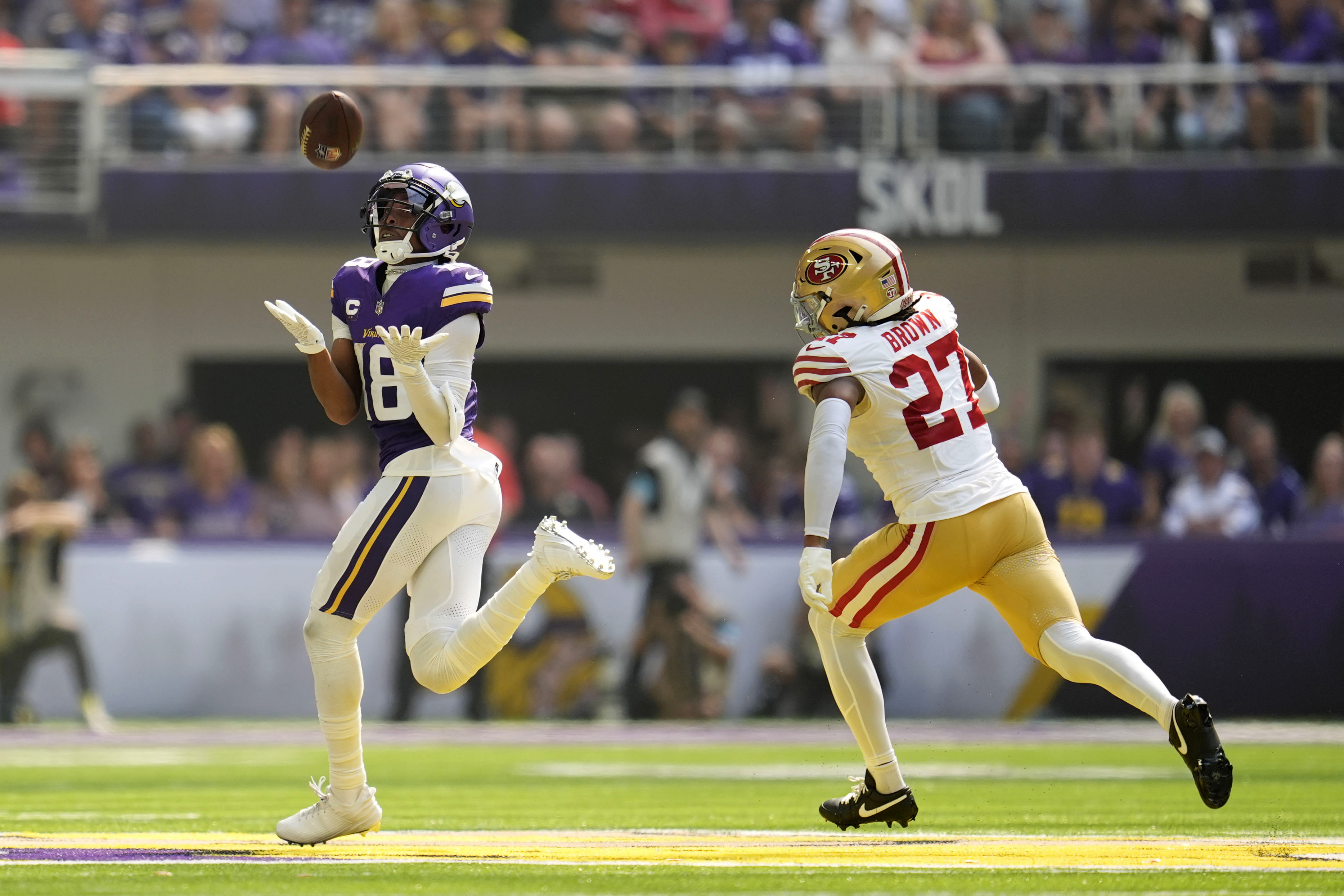 Minnesota Vikings wide receiver Justin Jefferson (18) catches a 97-yard touchdown pass over San Francisco 49ers safety Ji'Ayir Brown (27) during the first half of an NFL football game, Sunday, Sept. 15, 2024, in Minneapolis.