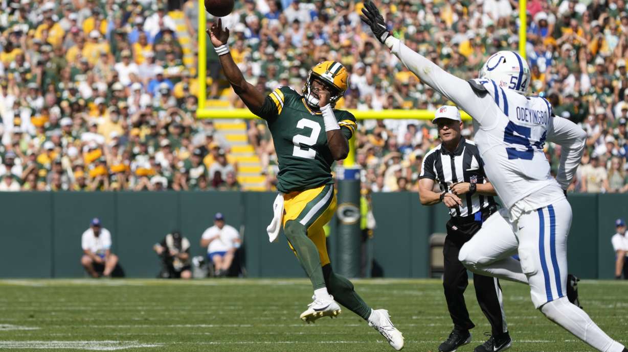 Green Bay Packers quarterback Malik Willis (2) throws on the run as Indianapolis Colts defensive end Dayo Odeyingbo (54) defends during the second half of an NFL football game Sunday, Sept. 15, 2024, in Green Bay, Wis.