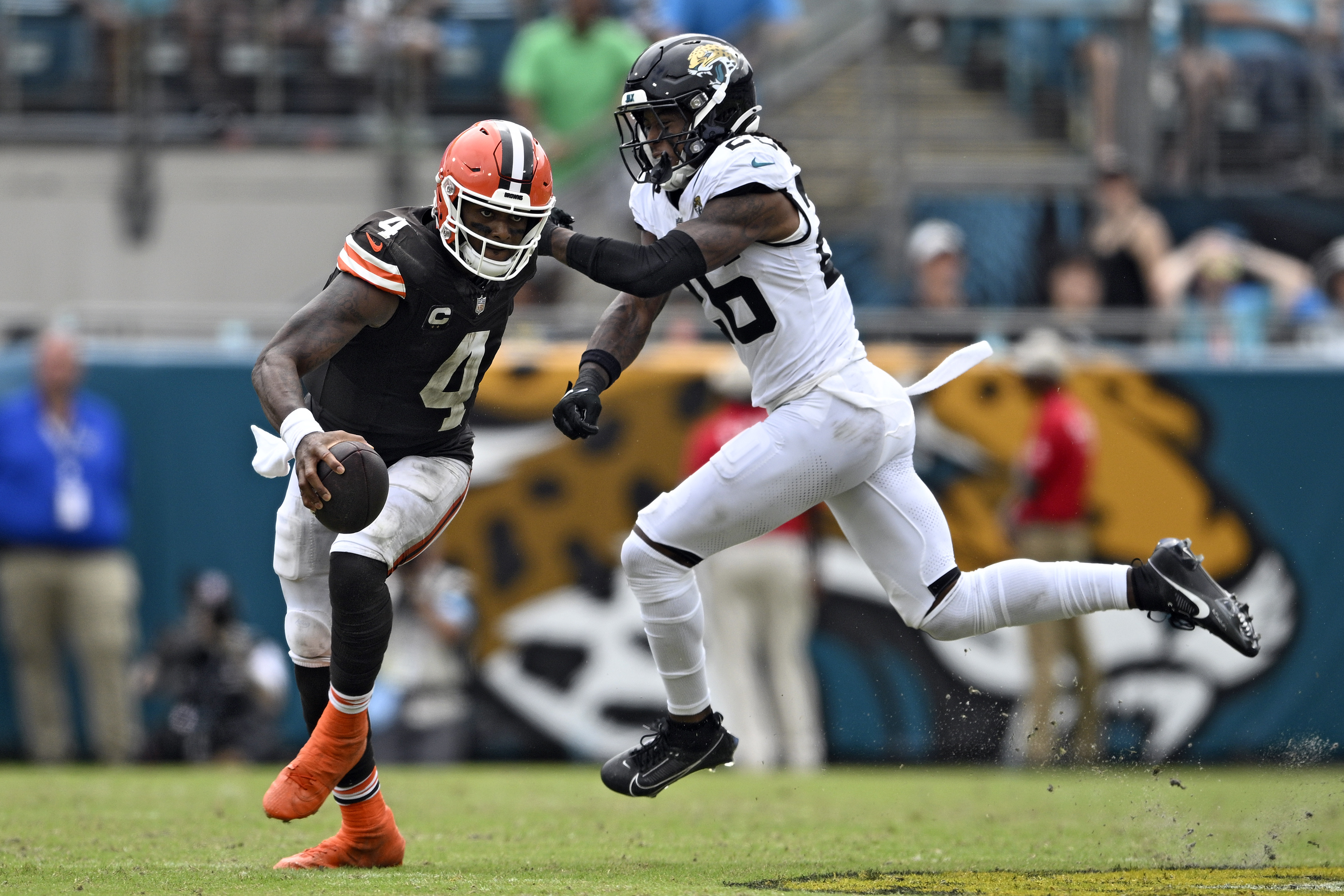 Cleveland Browns quarterback Deshaun Watson (4) scrambles away from Jacksonville Jaguars safety Antonio Johnson (26) during the second half of an NFL football game Sunday, Sept. 15, 2024, in Jacksonville, Fla.