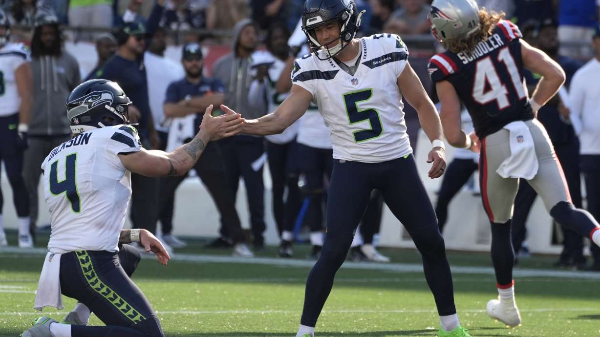 Seattle Seahawks place-kicker Jason Myers, center, celebrates with punter Michael Dickson, left, after Myers made the winning field goal in overtime of an NFL football game against the New England Patriots, Sunday, Sept. 15, 2024, in Foxborough, Mass.