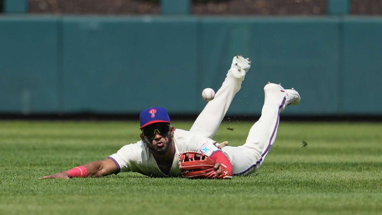Philadelphia Phillies' Johan Rojas is unable to catch a ball hit by New York Mets' Francisco Lindor during the first inning of a baseball game, Sunday, Sept. 15, 2024, in Philadelphia.