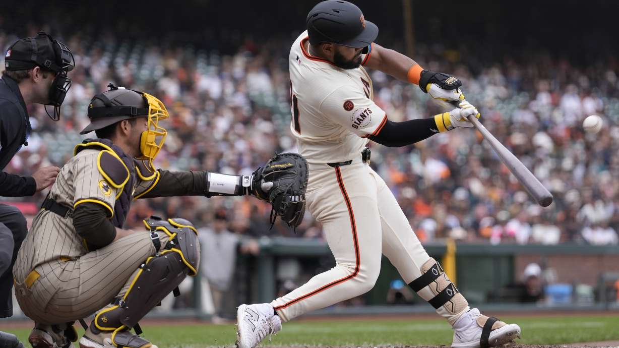 San Francisco Giants' Heliot Ramos, right, hits a home run in front of San Diego Padres catcher Kyle Higashioka during the ninth inning of a baseball game in San Francisco, Sunday, Sept. 15, 2024.