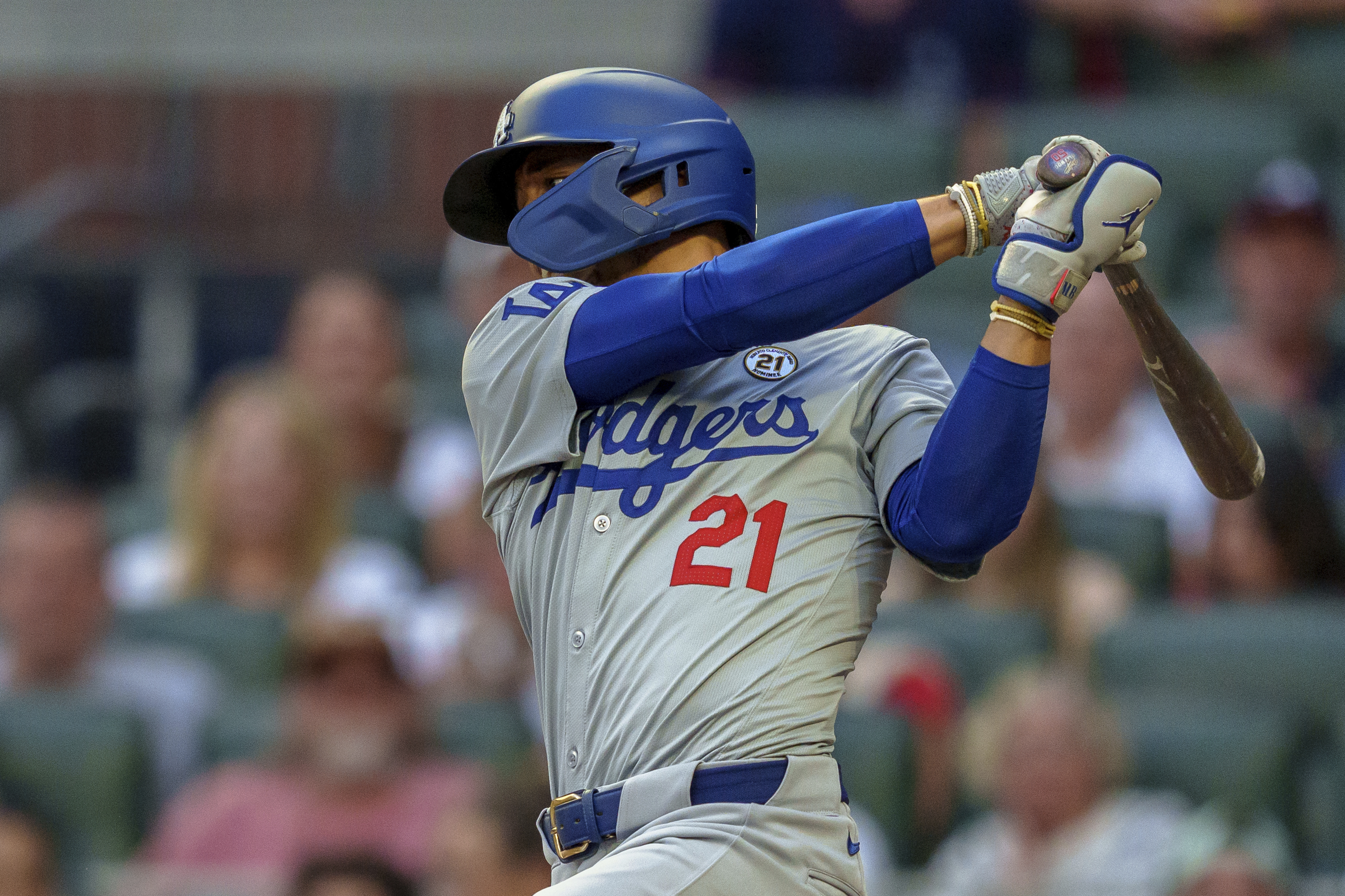 Los Angeles Dodgers' Mookie Betts swings at the pitch in the first inning of a baseball game wearing 21 in commemoration of Roberto Clemente against the the Atlanta Braves, Sunday, Sept. 15, 2024, in Atlanta.