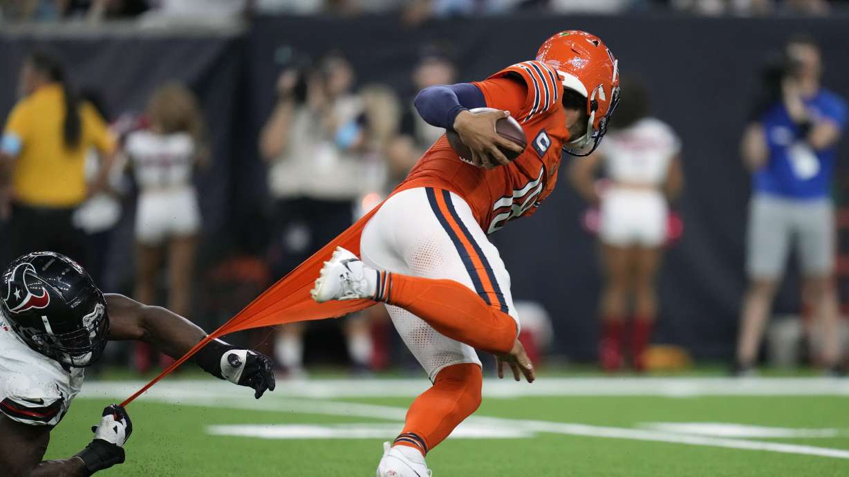 Chicago Bears quarterback Caleb Williams, right, scrambles away from Houston Texans defensive end Danielle Hunter during the second half of an NFL football game Sunday, Sept. 15, 2024, in Houston.
