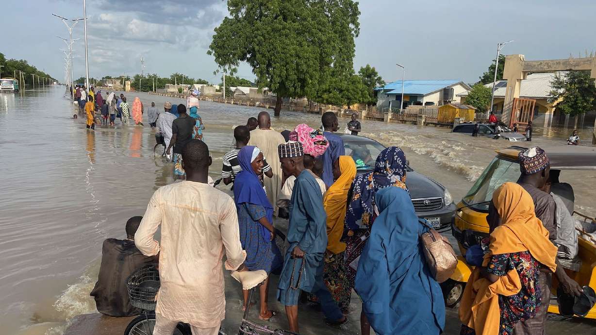 Residents leave the flooded areas with their belongings in Maiduguri, northern Borno state, Nigeria on Sunday. At least 274 inmates have escaped from a prison in Nigeria's Borno state following heavy flooding.