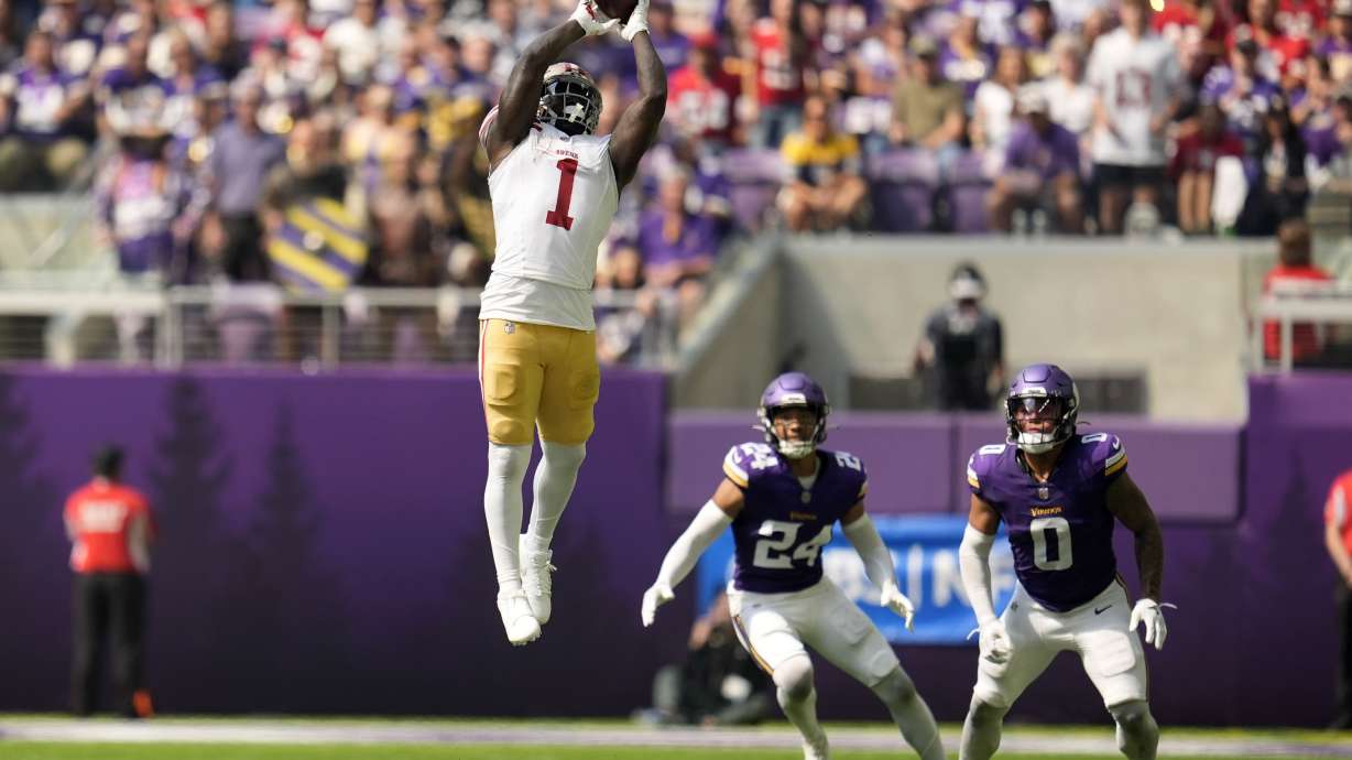 San Francisco 49ers wide receiver Deebo Samuel Sr. (1) catches a pass over Minnesota Vikings safety Camryn Bynum (24) and linebacker Ivan Pace Jr. (0) during the first half of an NFL football game, Sunday, Sept. 15, 2024, in Minneapolis.